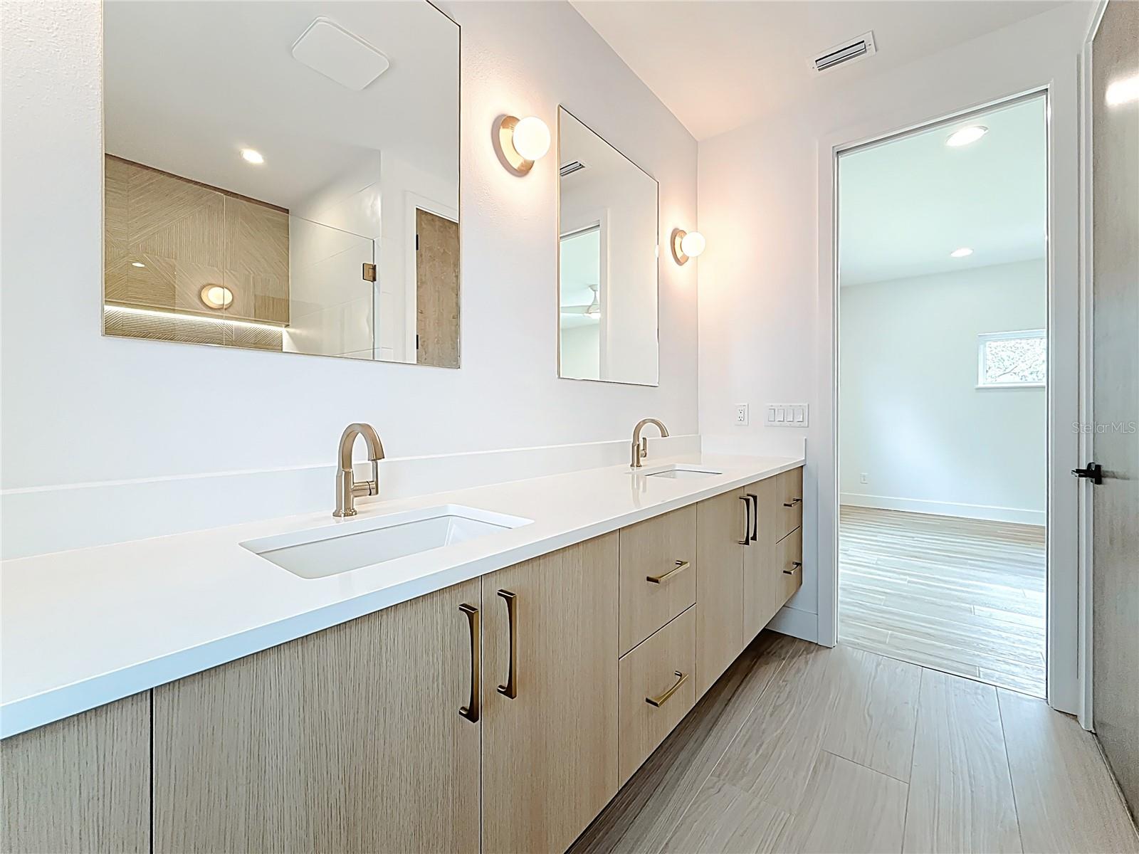 Spa-like en-suite bath featuring dual sinks, an oversized walk-in shower, and a private water closet.