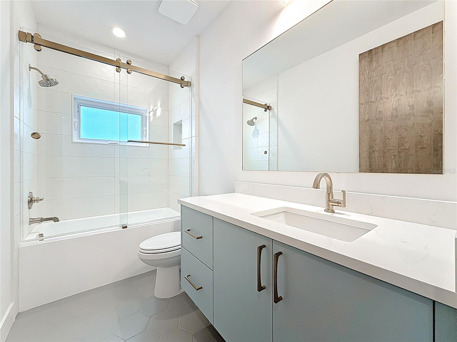 Stylish guest bath with tub/shower combo and sleek modern finishes.