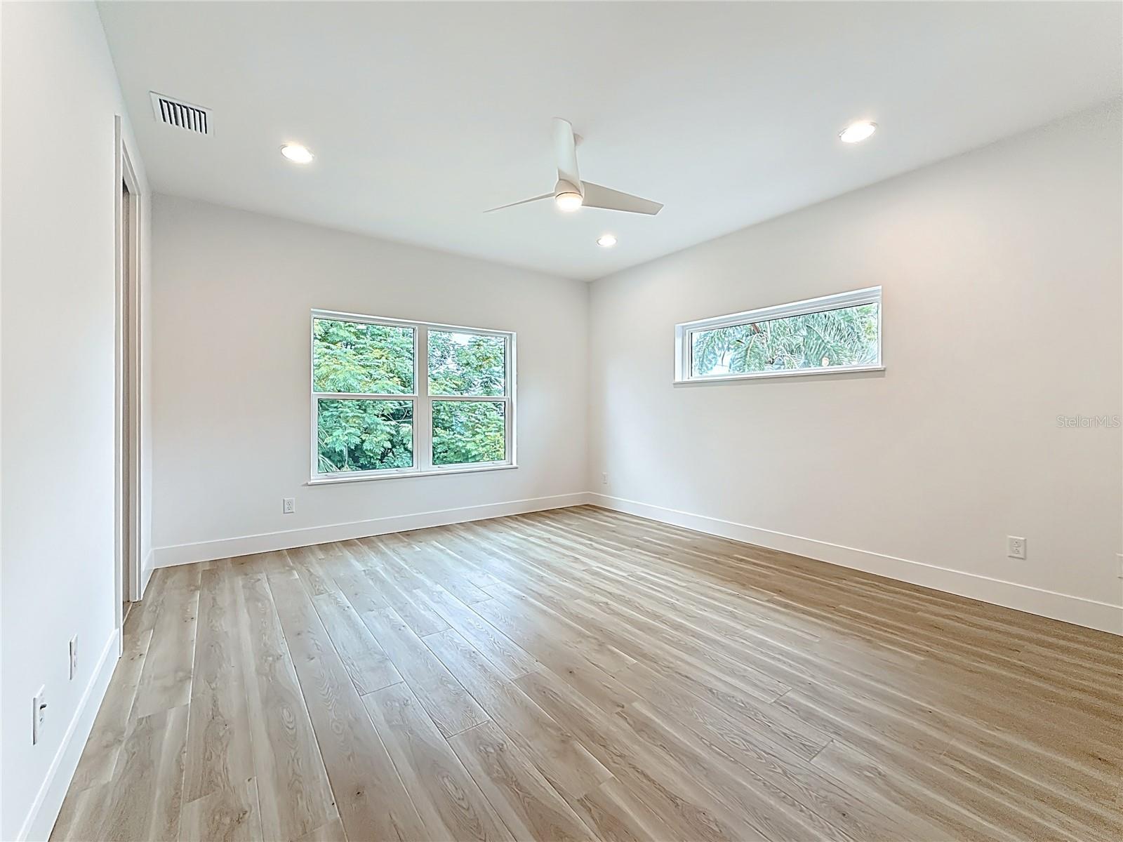 Elegant Primary Bedroom upstairs featuring a sleek en suite bath and abundant natural light.