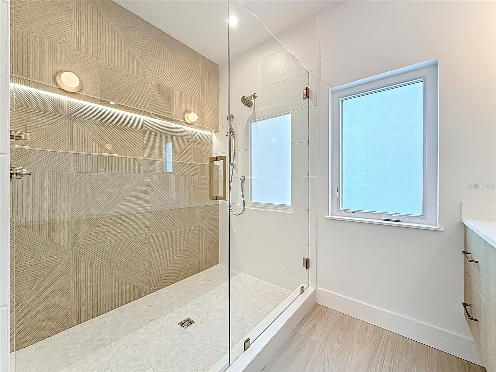Spa-like en-suite bath featuring dual sinks, an oversized walk-in shower, and a private water closet.
