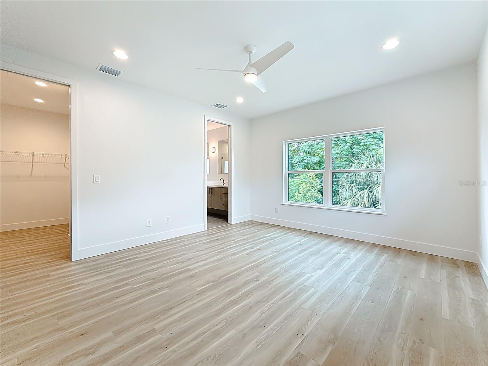 Elegant Primary Bedroom upstairs featuring a sleek en suite bath and abundant natural light.