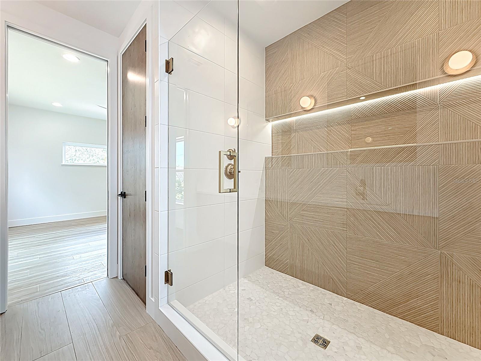 Spa-like en-suite bath featuring dual sinks, an oversized walk-in shower, and a private water closet.