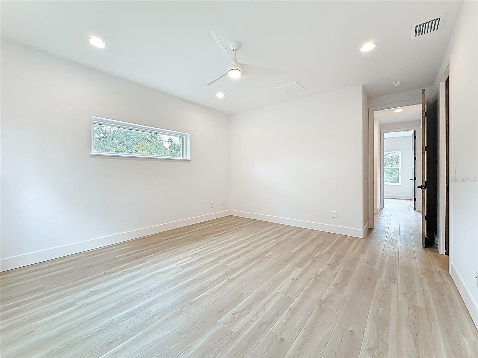 Elegant Primary Bedroom upstairs featuring a sleek en suite bath and abundant natural light.