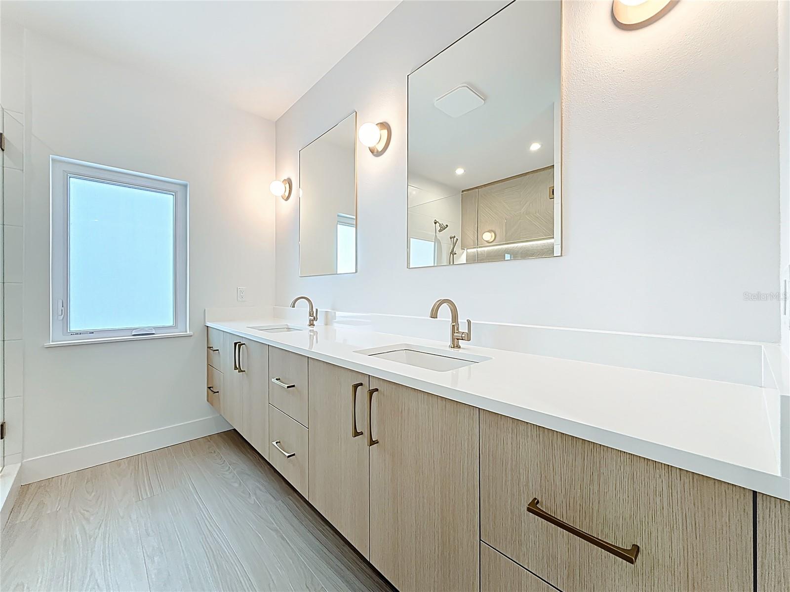Spa-like en-suite bath featuring dual sinks, an oversized walk-in shower, and a private water closet.