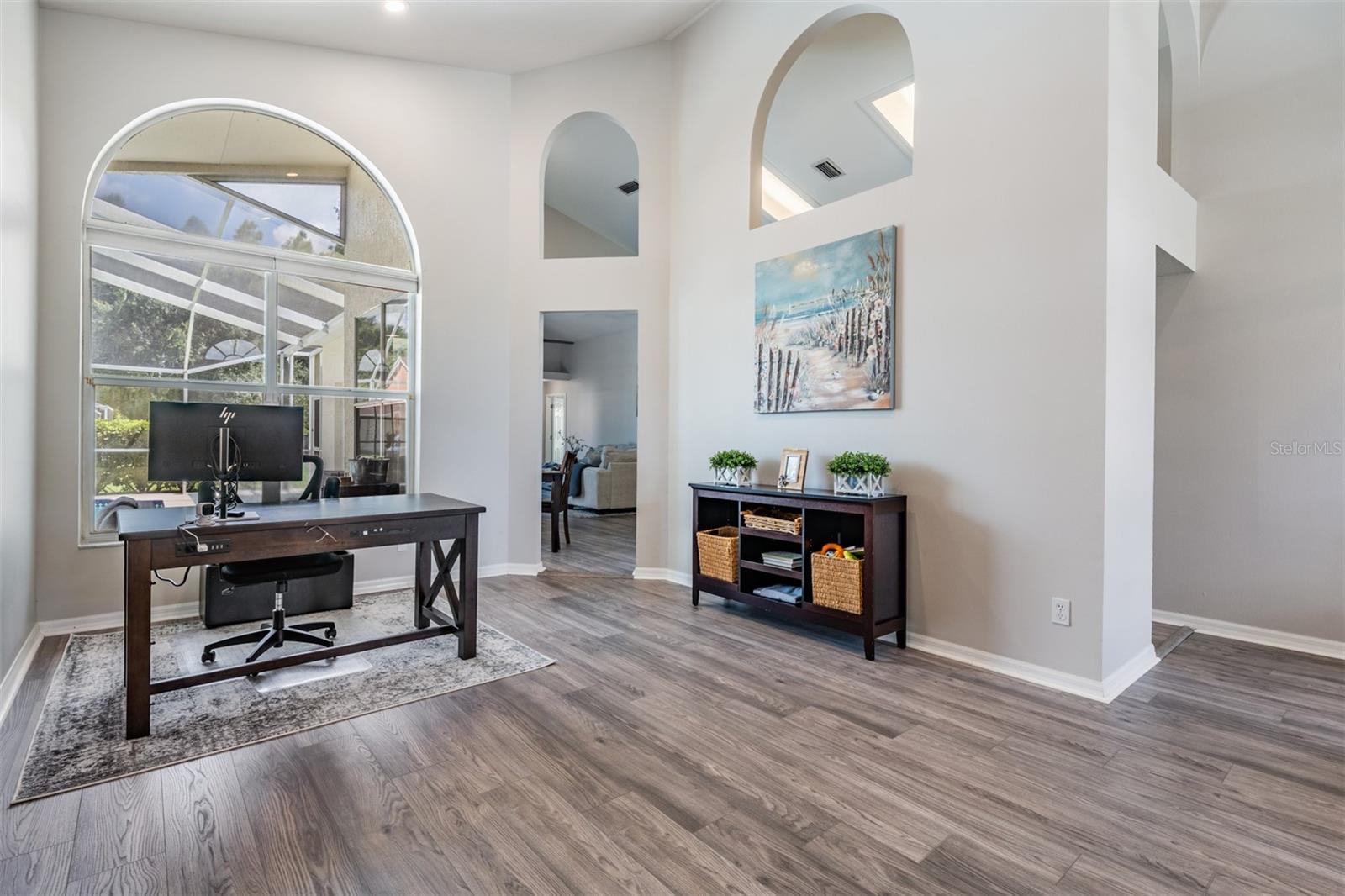 Formal Living Room area ( this family uses this space as an office and a play area for the children). New LVP Flooring, Vaulted Ceilings, Inset Lighting, Ceiling fan with light fixture.