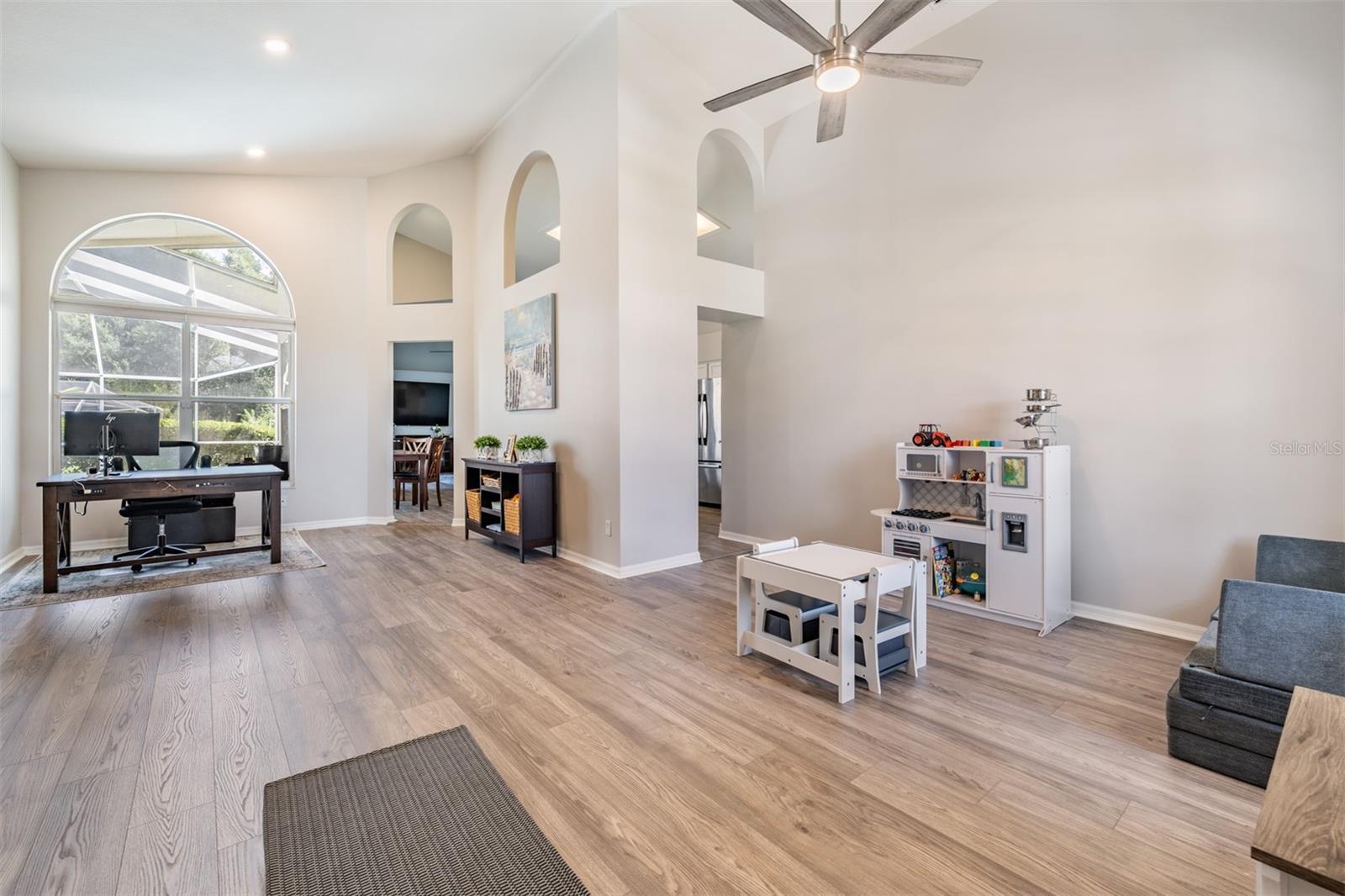 Formal Dining Room and Living Room area ( this family uses this space as an office and a play area for the children). New LVP Flooring, Vaulted Ceilings, Inset Lighting, Ceiling fan with light fixture.