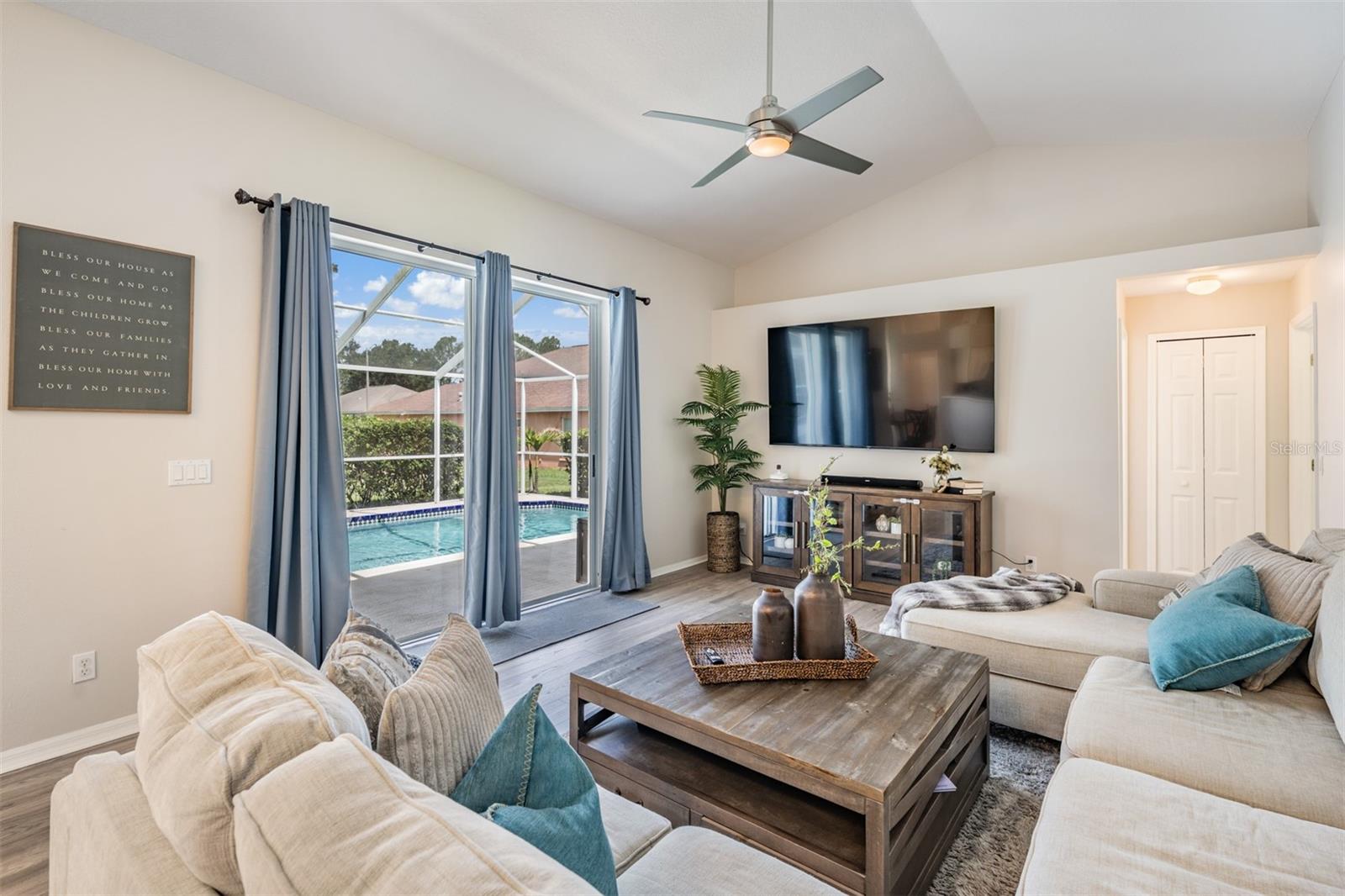 Large Great Room, vaulted ceilings, New Flooring and Ceiling fan with light fixture, overlooking the pool/lanai.