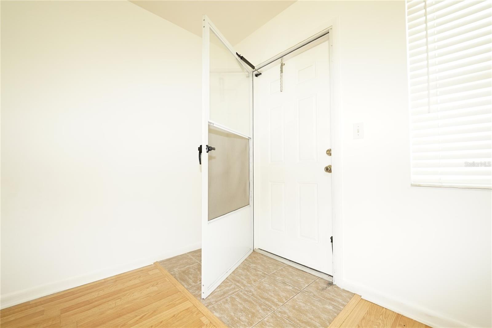 Exterior door and storm door visible.