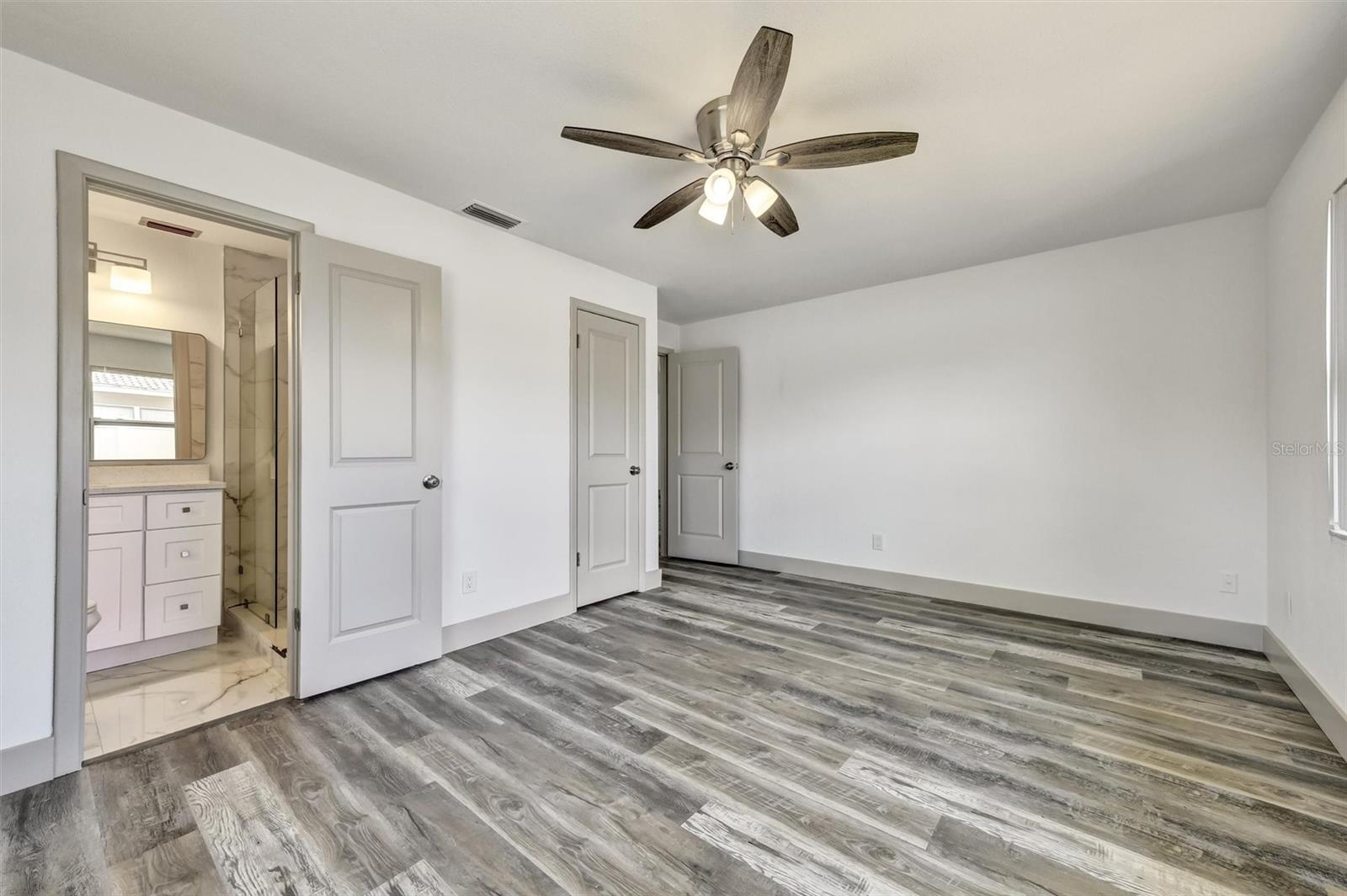 Primary bed looking towards en-suite bath and closet