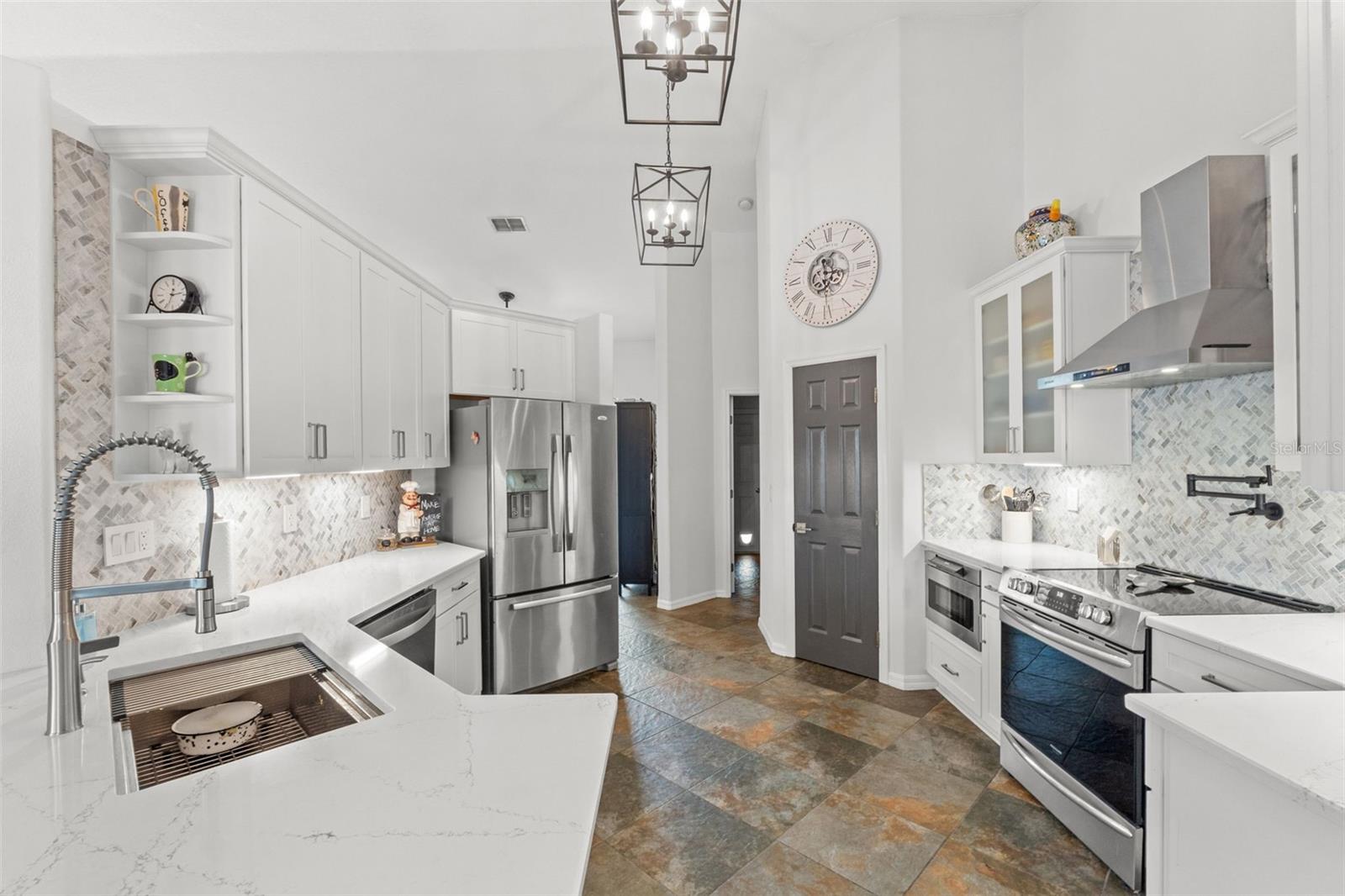 Spacious kitchen with quartz countertops and custom hood