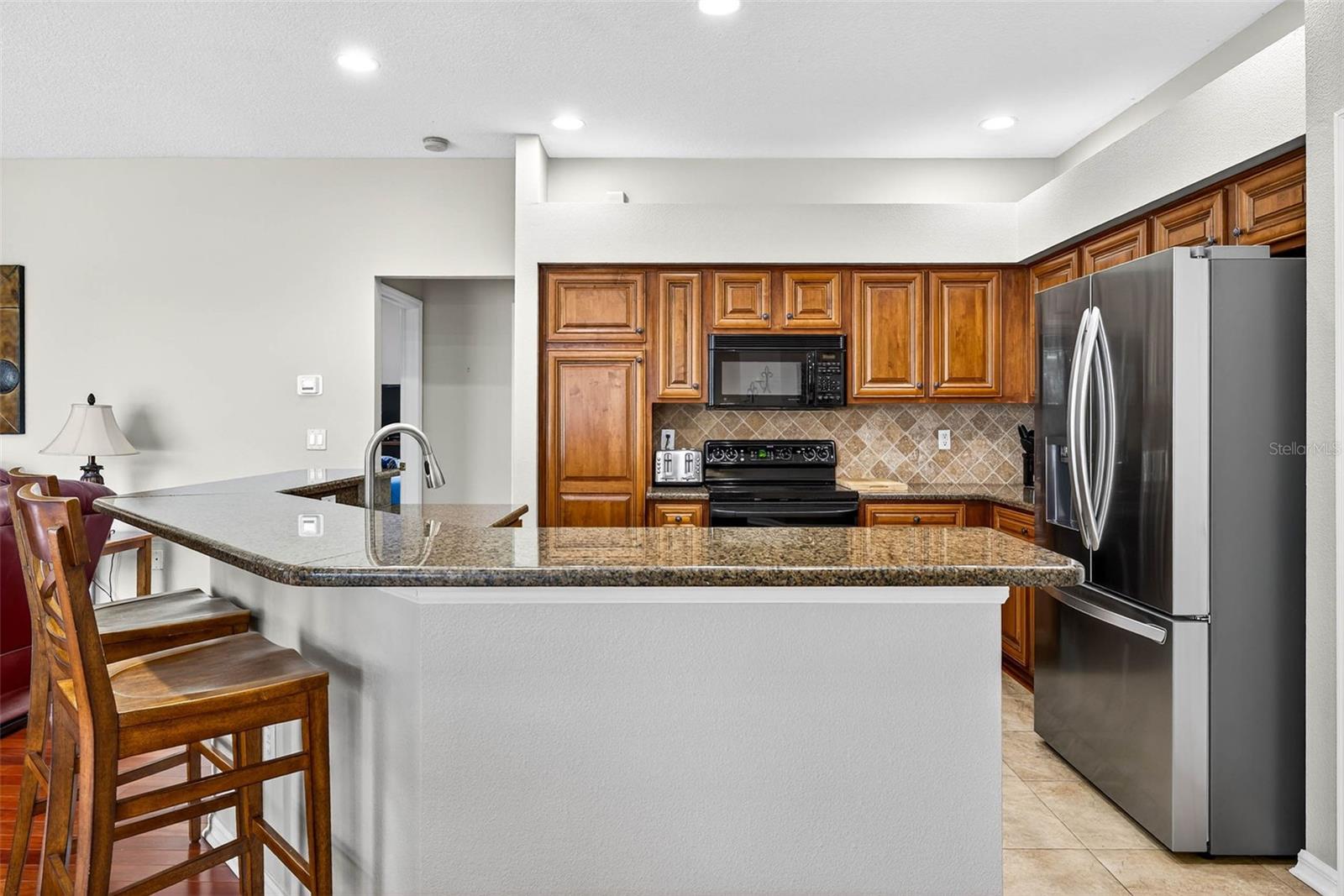 Granite counters, wood cabinetry and stainless appliances