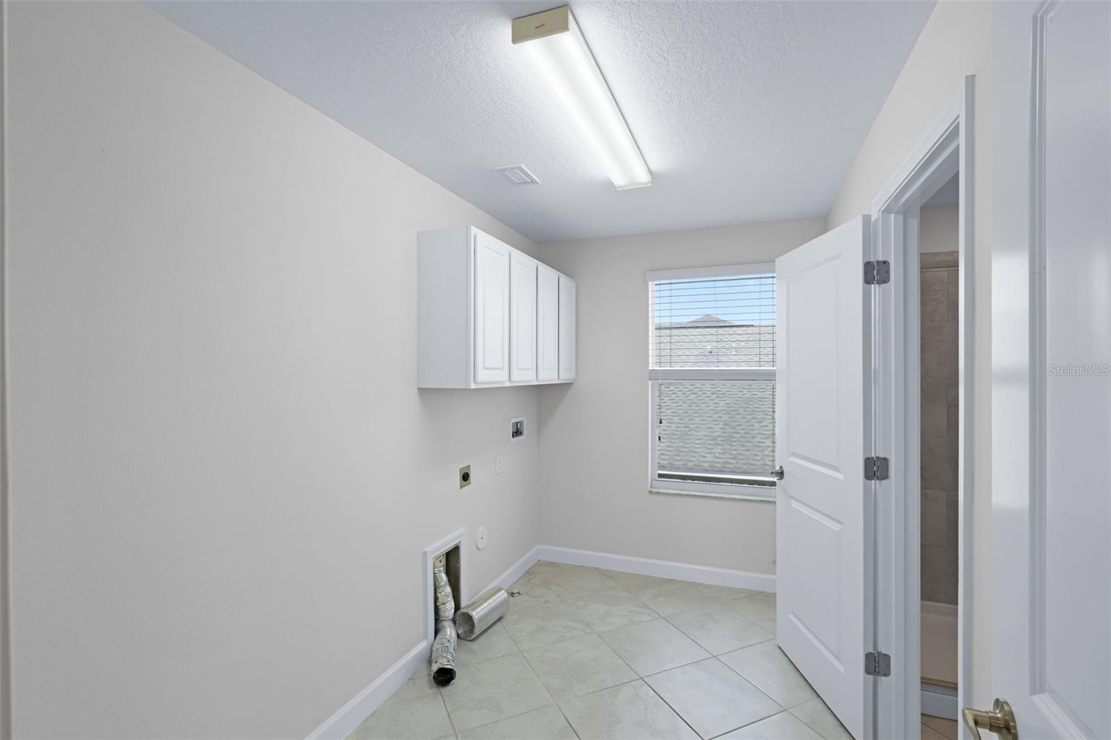 Laundry room (upstairs) with access to the primary bathroom