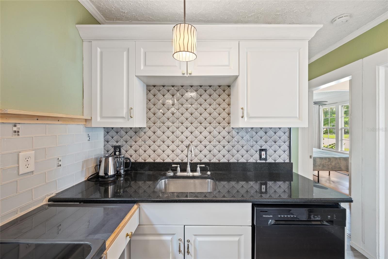 Graphic backsplash and granite counter with a little shelf for a favorite serving platter or your every day items like oils