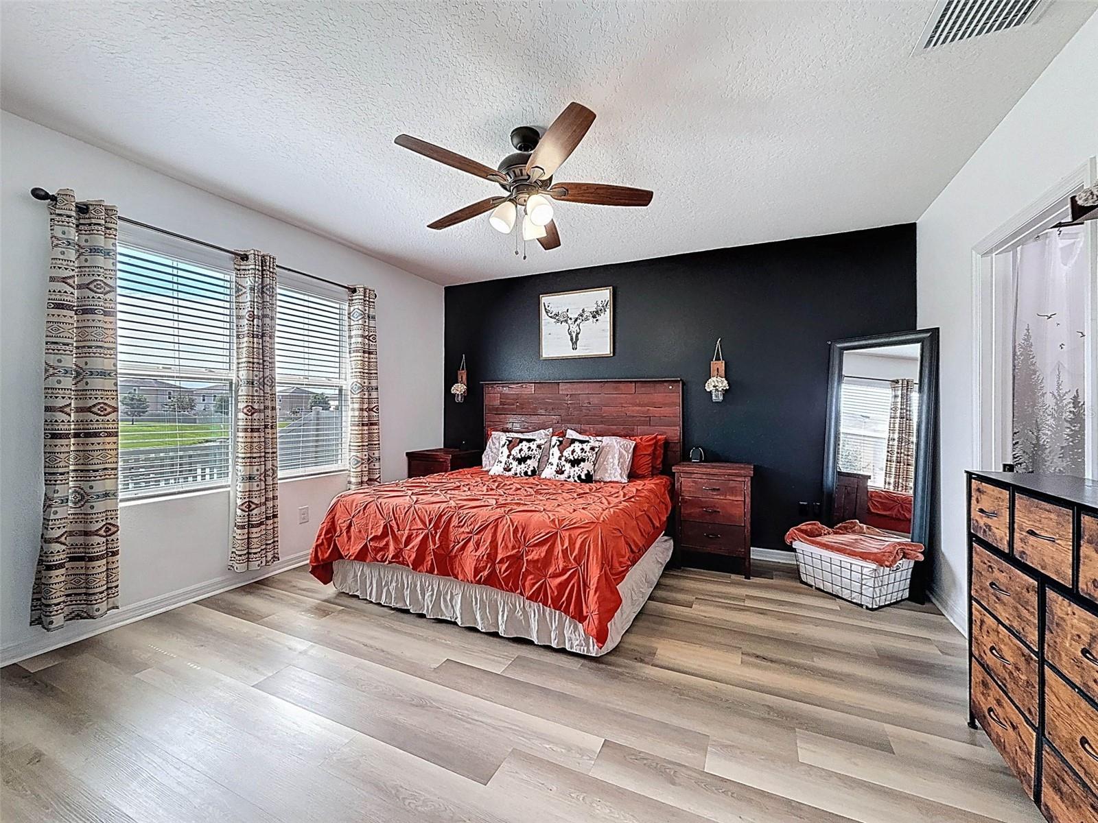 PRIMARY BEDROOM WITH EN SUITE BATH IS SPACIOUS AND LARGE DOUBLE WINDOWS OVERLOOKING THE WATER