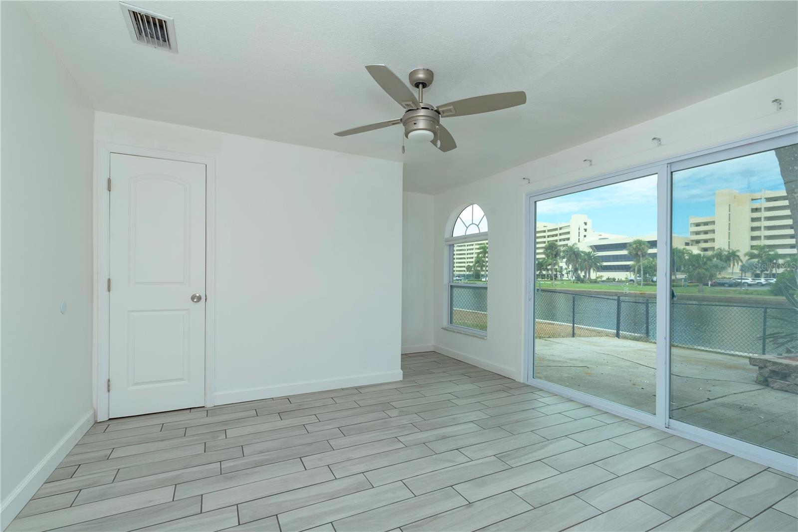 Bedroom 3 has sliders to back yard and a water view.