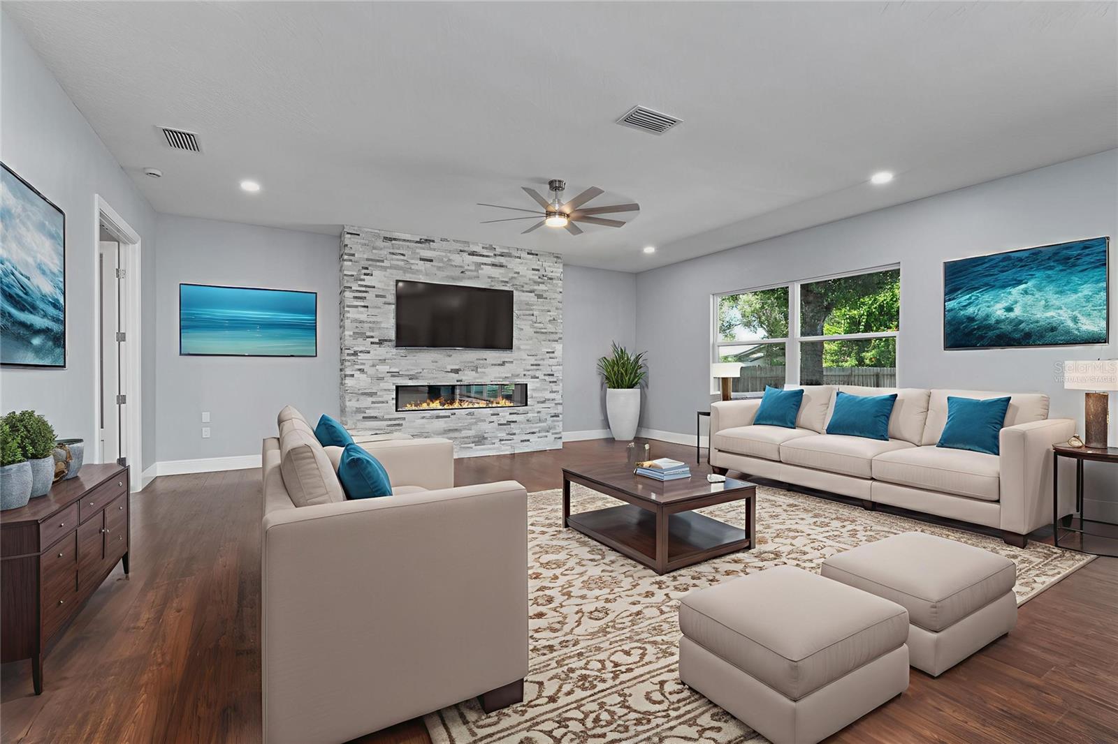 Virtually staged Spacious Family Room with stylish stone fireplace, French Doors to left lead to Office