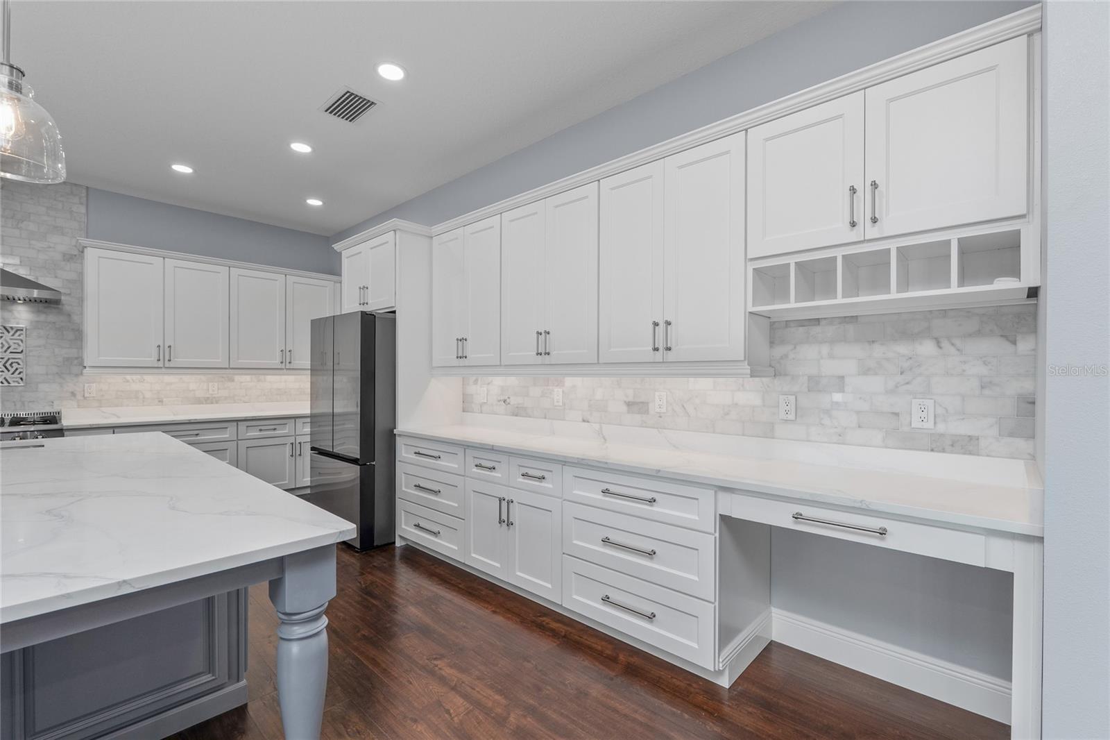 The tile backsplash accents the quartz countertops and gorgeous cabinets