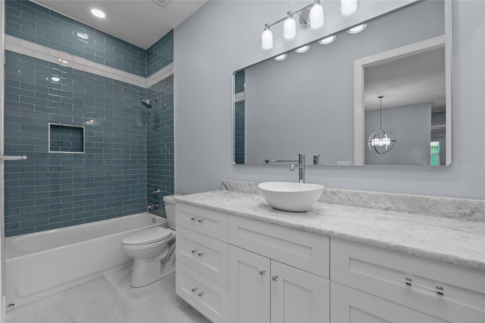 Beautiful Full bathroom at top of the stairs with floor to ceiling tile in the shower/tub area