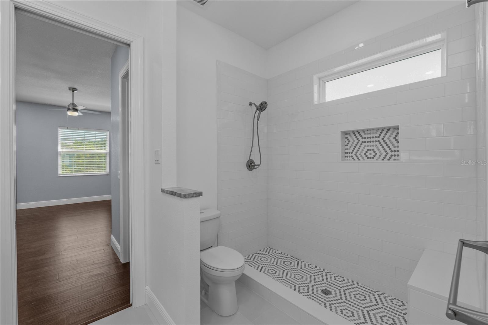 Jack and Jill Bathroom between Bedrooms 3 and 4 has a spacious shower with a decorative niche