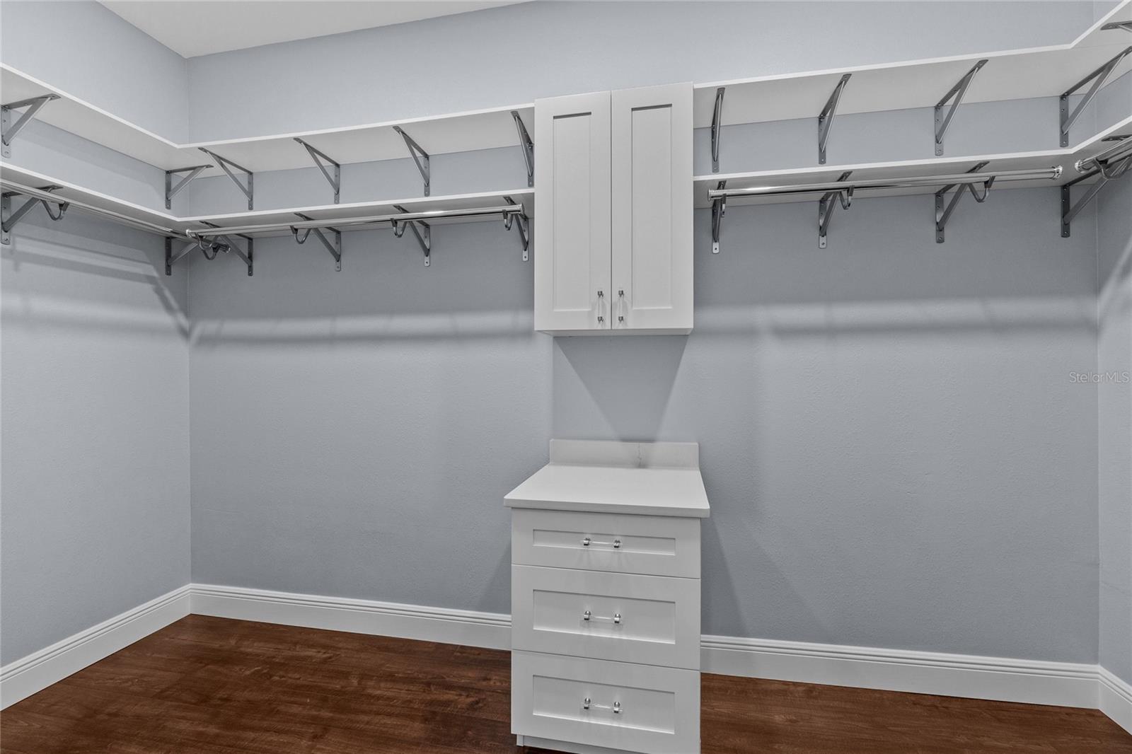 There are two of these custom closets in the primary suite complete with drawers, cabinet and quartz countertop