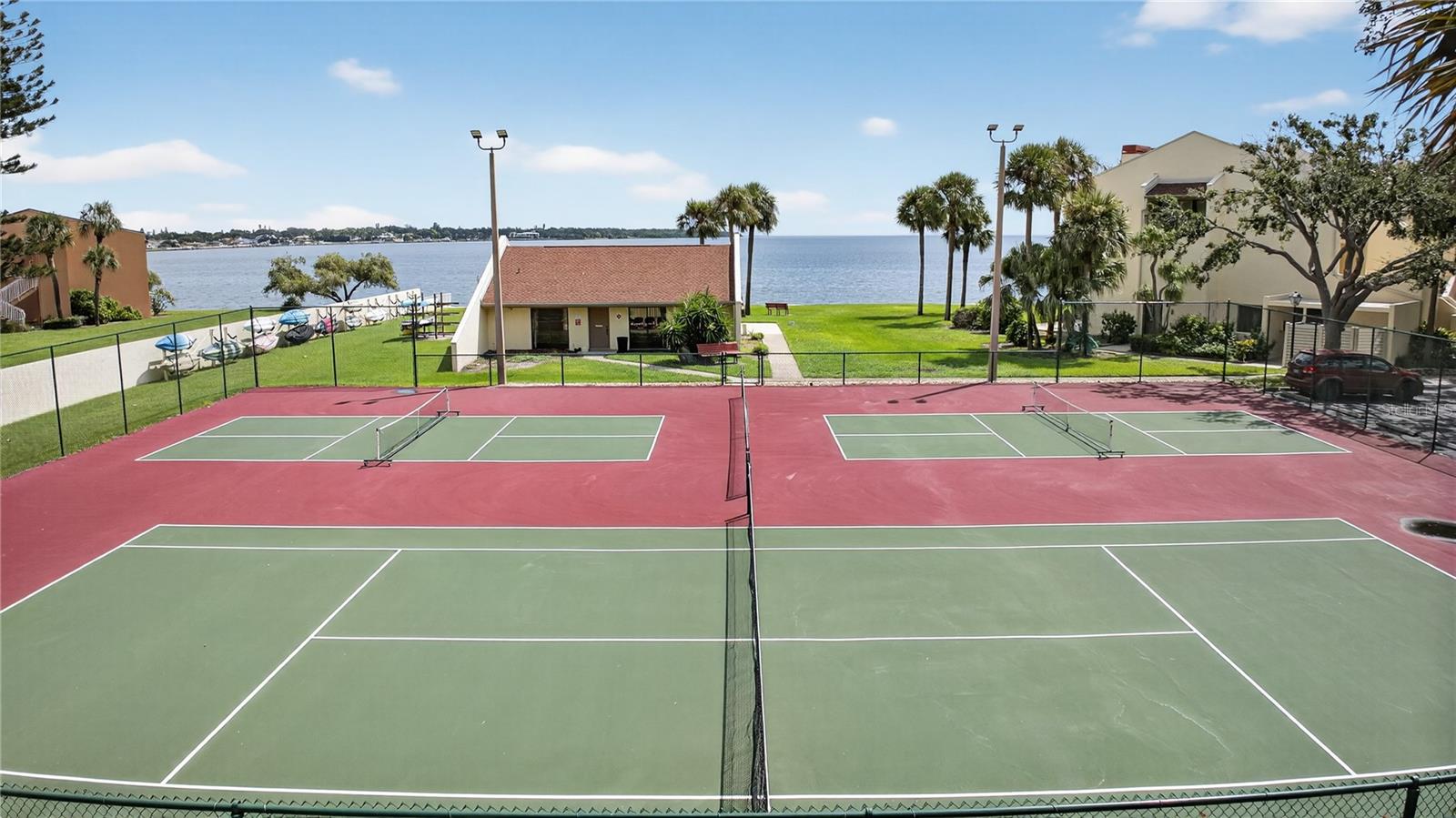 Clubhouse with kayaks pictured behind tennis & Pickleball courts