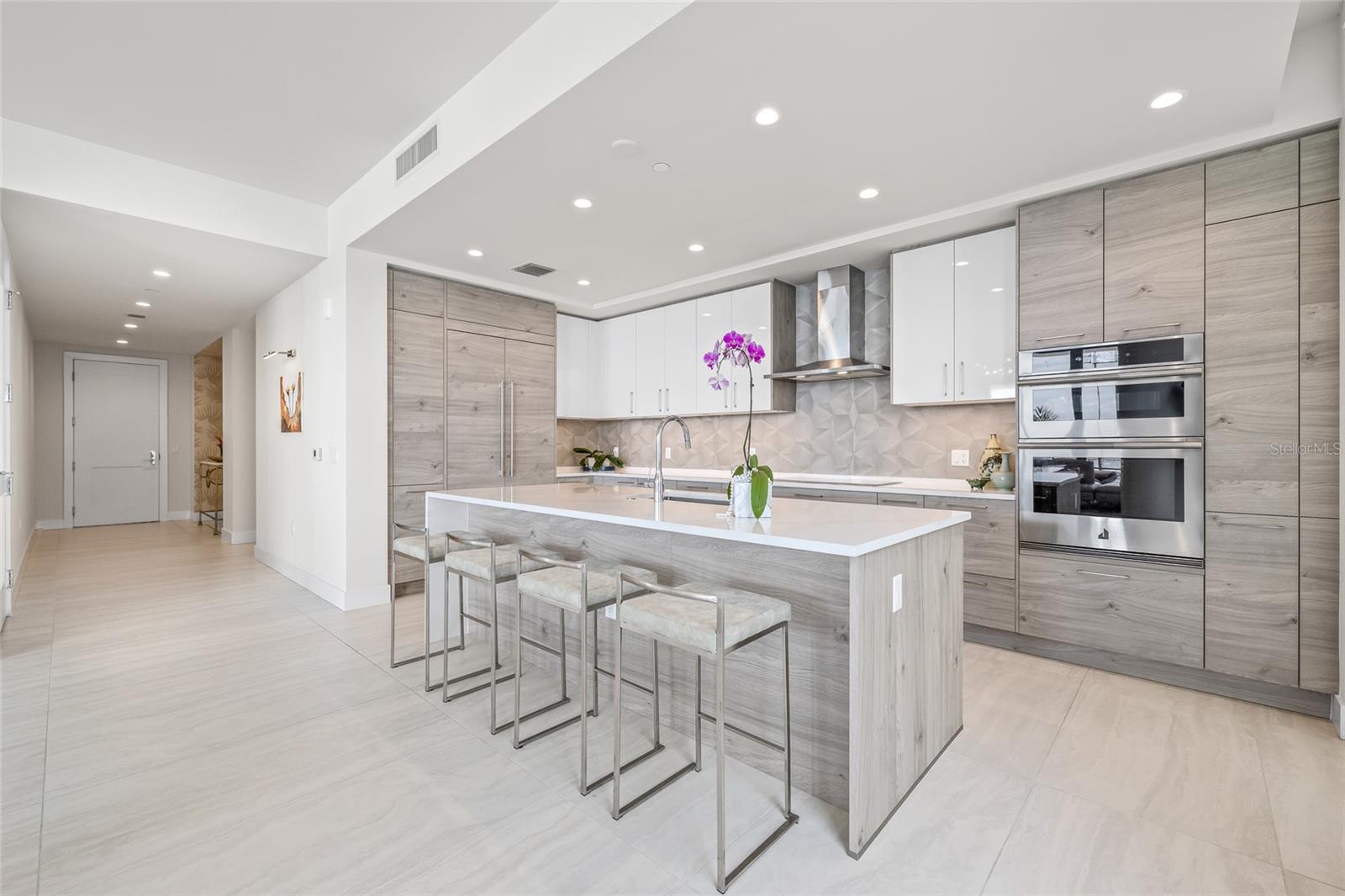The refrigerator is seamlessly integrated with matching paneled cabinetry for a sleek, cohesive look.