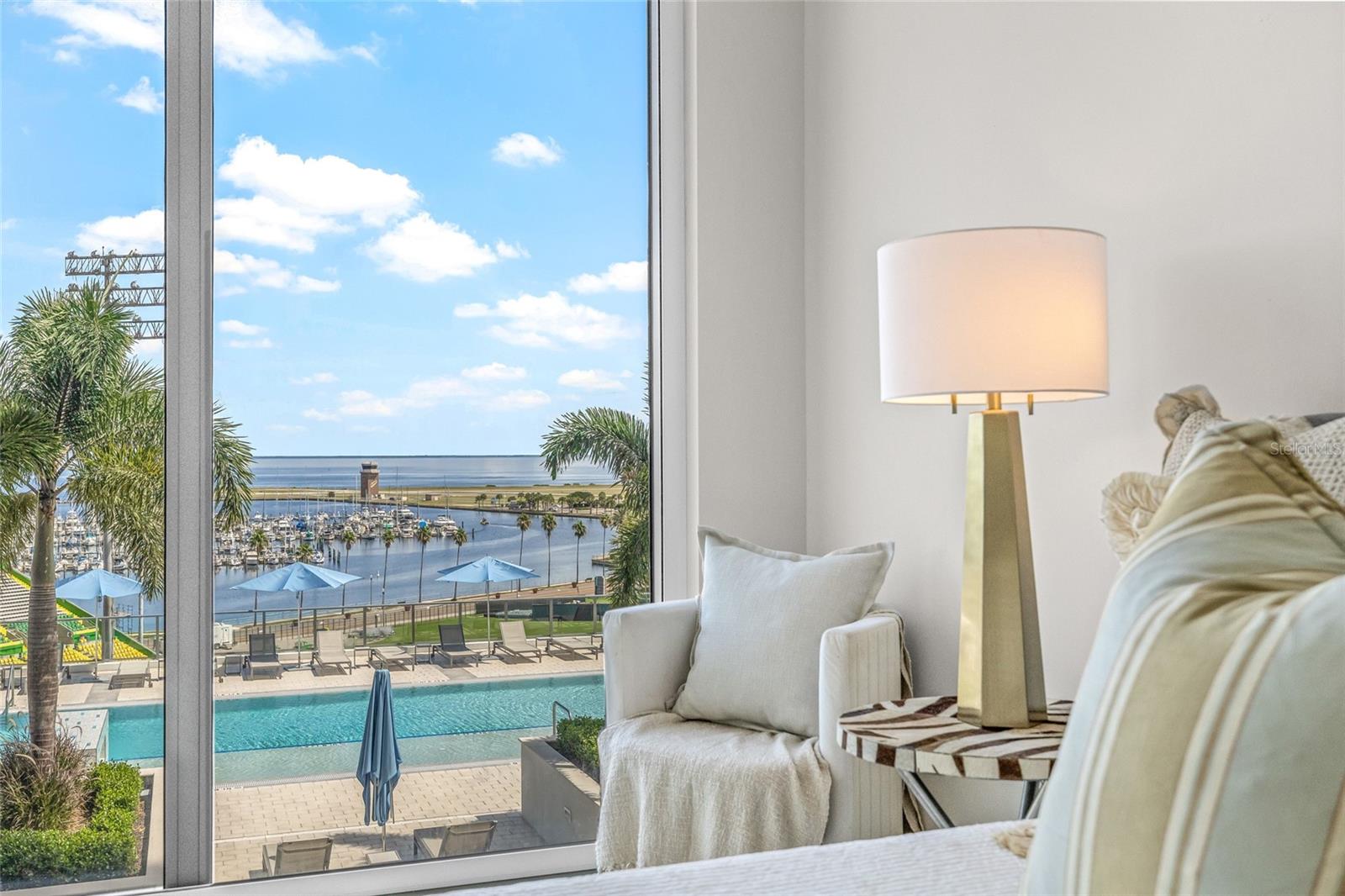 Wake up to stunning water views framed by floor-to-ceiling windows in the primary bedroom.