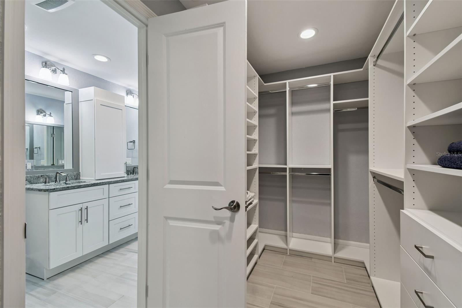 Custom primary closet with pull-out ironing board.