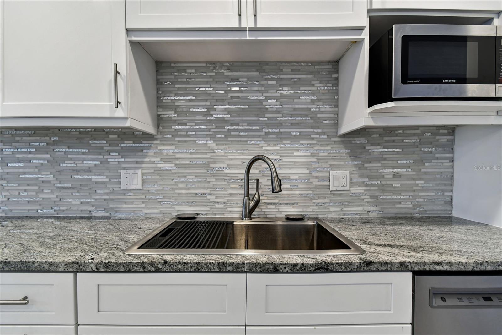 Double stainless-steel sink with decorative backsplash.