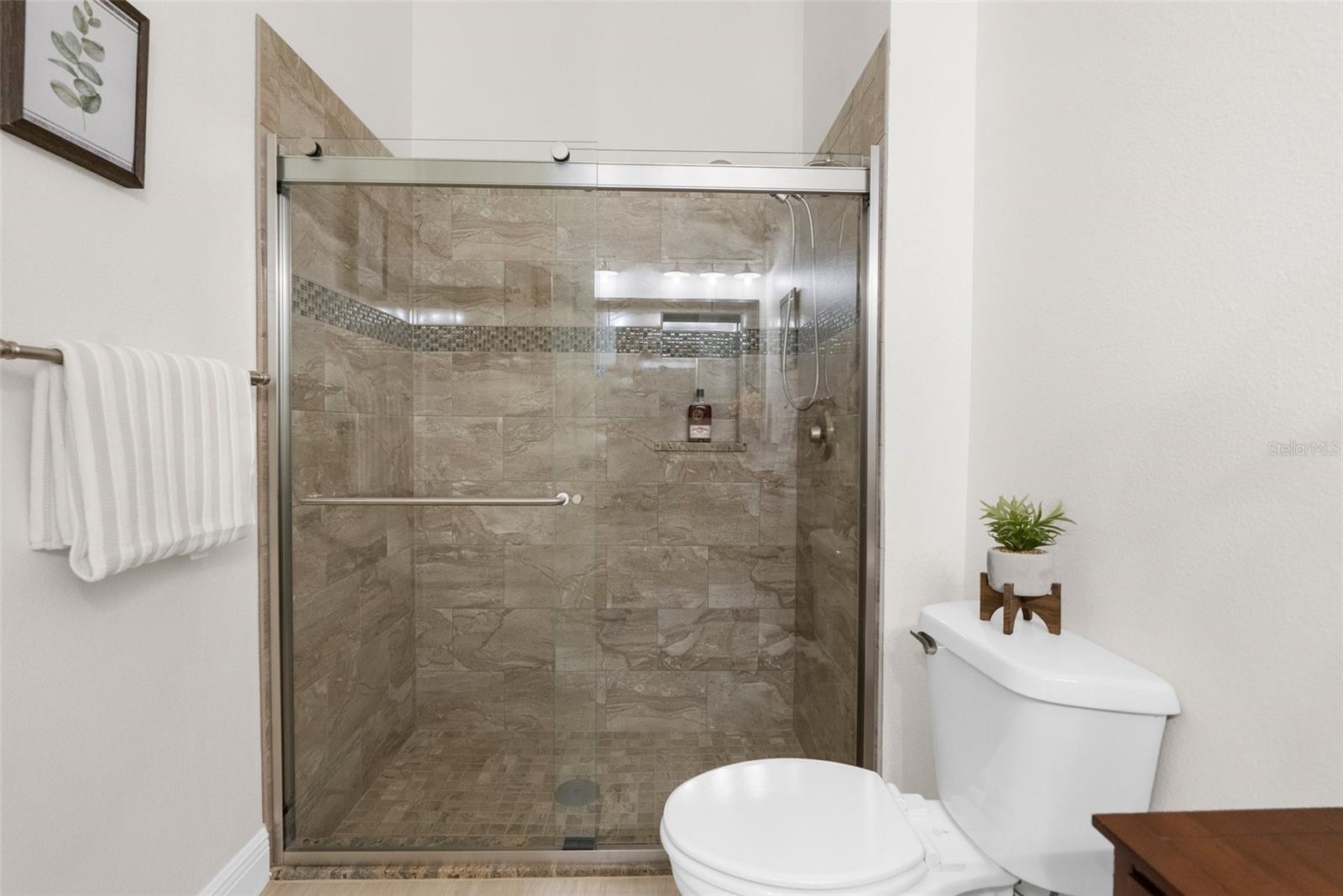 Guest bath with roomy, semi frameless shower.