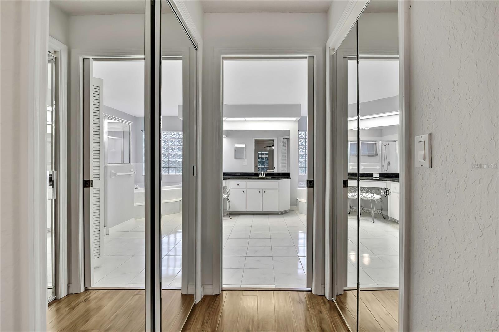 Primary bathroom hallway has a walk in closet on the right and a double closet on the left