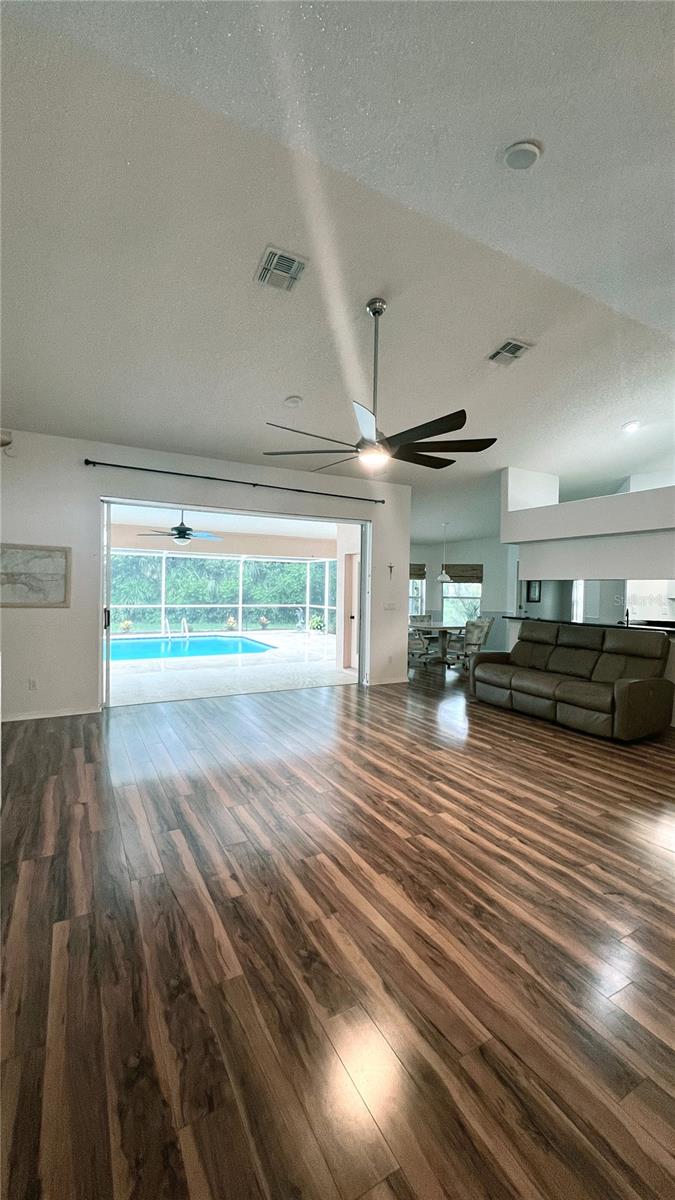 Great room has vaulted ceiling and ceiling speakers for entertainment center which also plays music in the pool area lanai.
