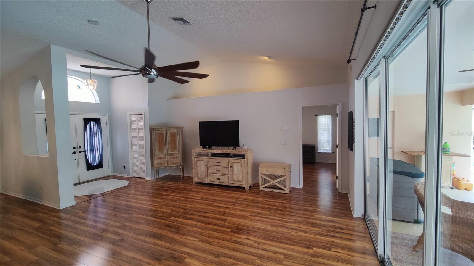 Great room looking at the primary bedroom through the door on the right has gorgeous woof flooring which continues into bedrooms.  Split bedroom plan for your privacy and comfort.