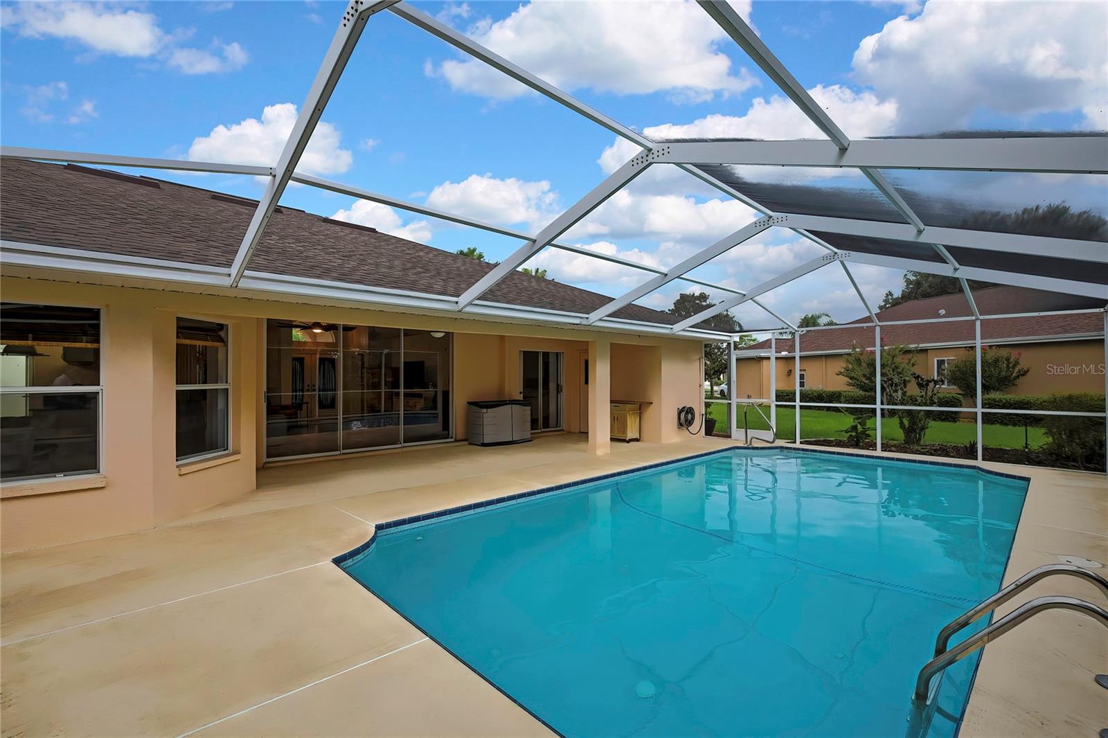 Screened in pool with covered lanai has an outdoor shower and a half bath changing room.