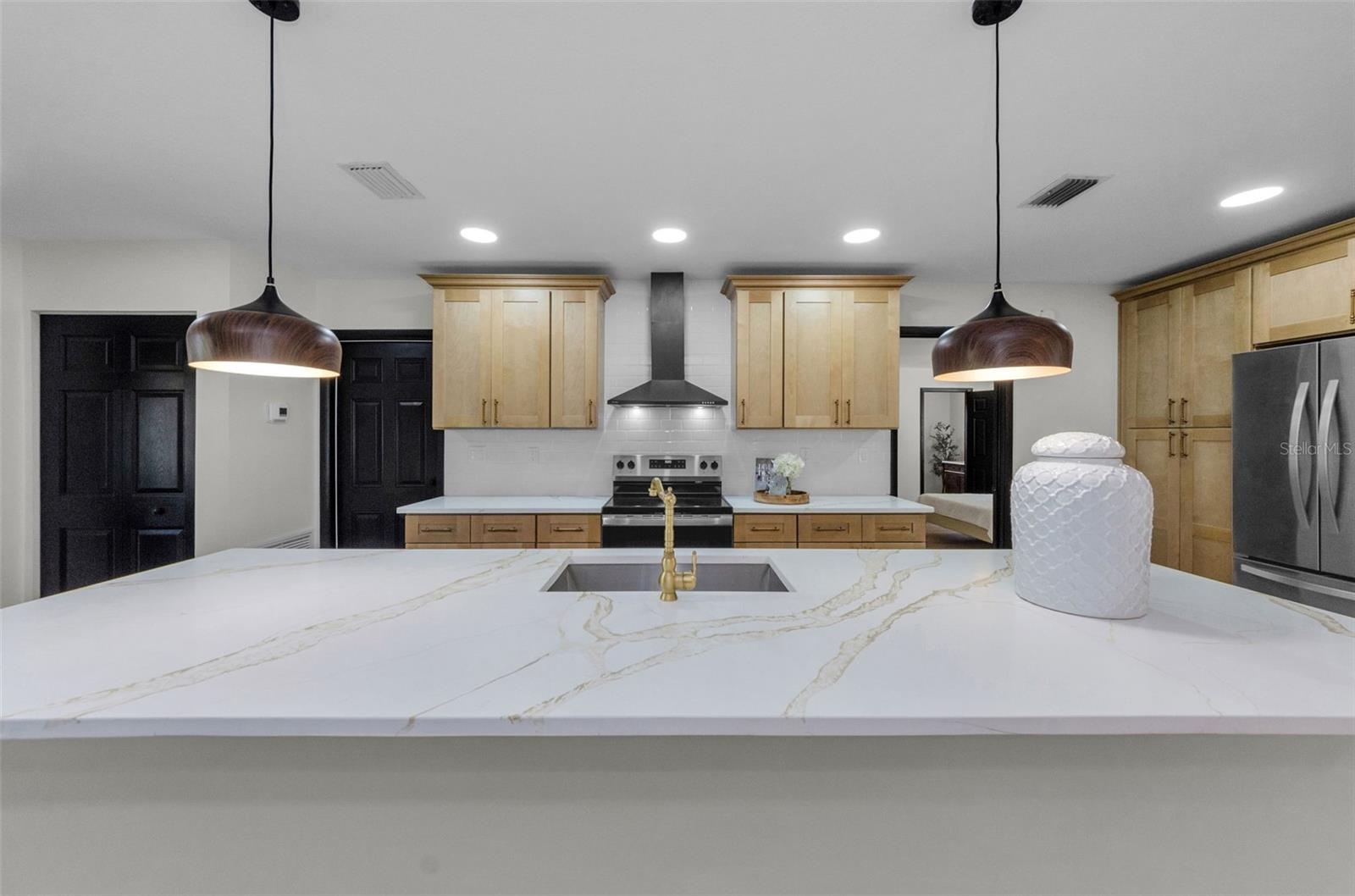 GLEAMING QUARTZ COUNTERTOPS, MODERN PENDANT LIGHTS, LARGE SINK, ANTIQUE BRASS FAUCET!