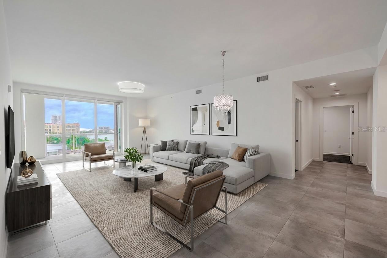 The dining/living room framed by floor to ceiling 'hurricane impact sliders' and a view of the entrance to the primary suite
