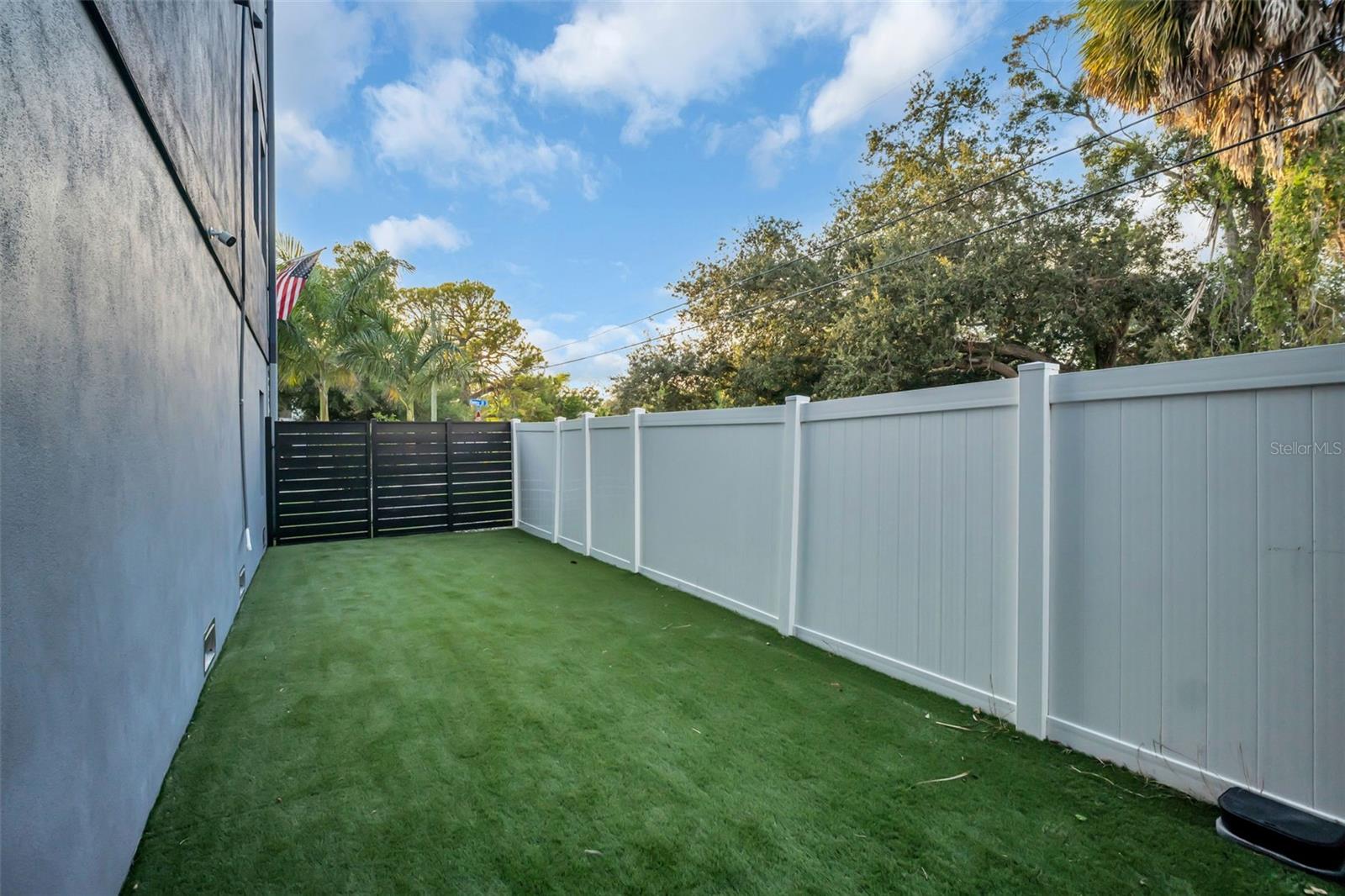 dog run on side of house. With pet friendly artifical grass.