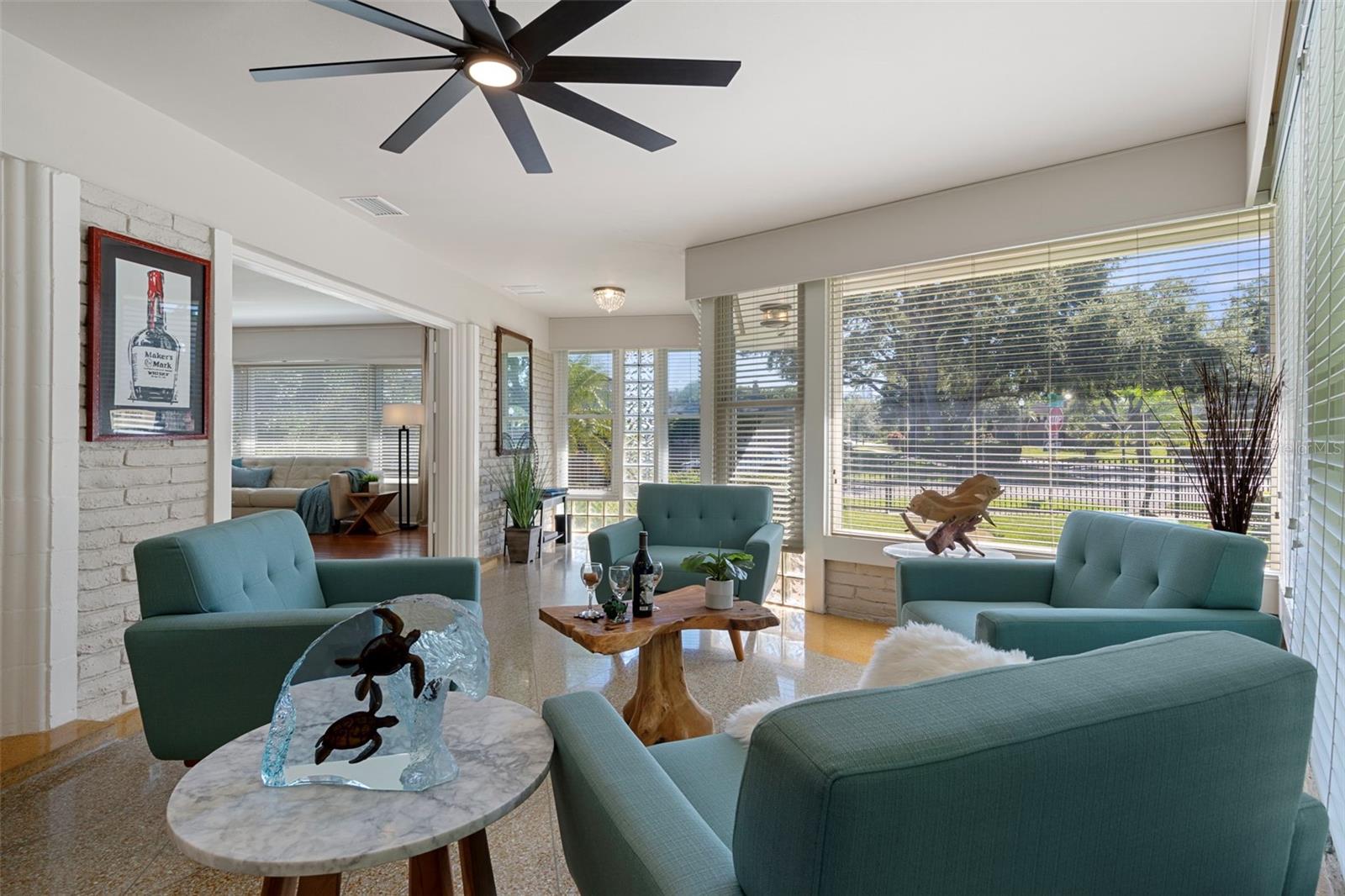 This sunroom with original terrazo floors features windows on 3 sides.