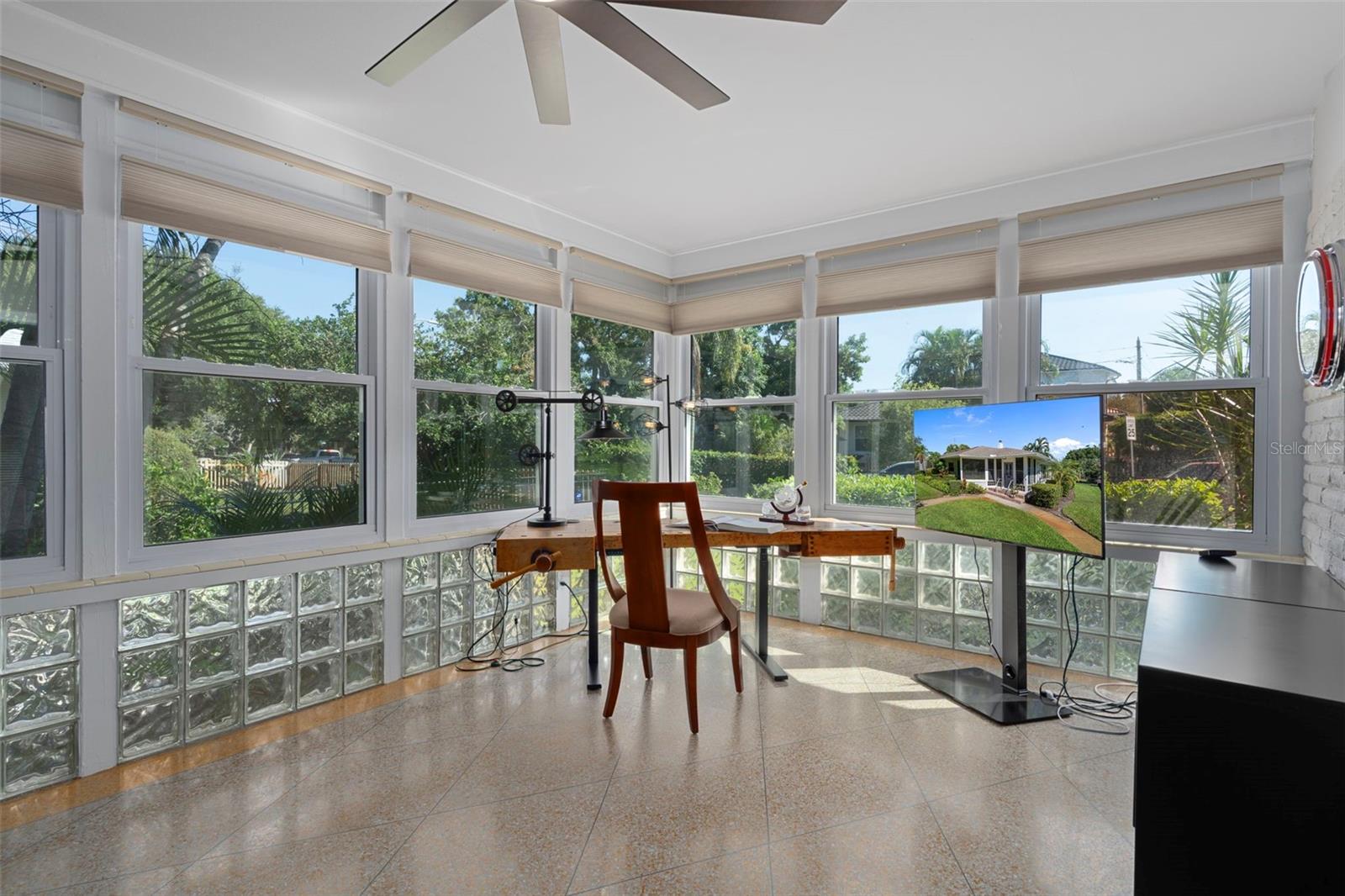 Sunlit den surrounded by glass-block accents and windows overlooking the lush yard.