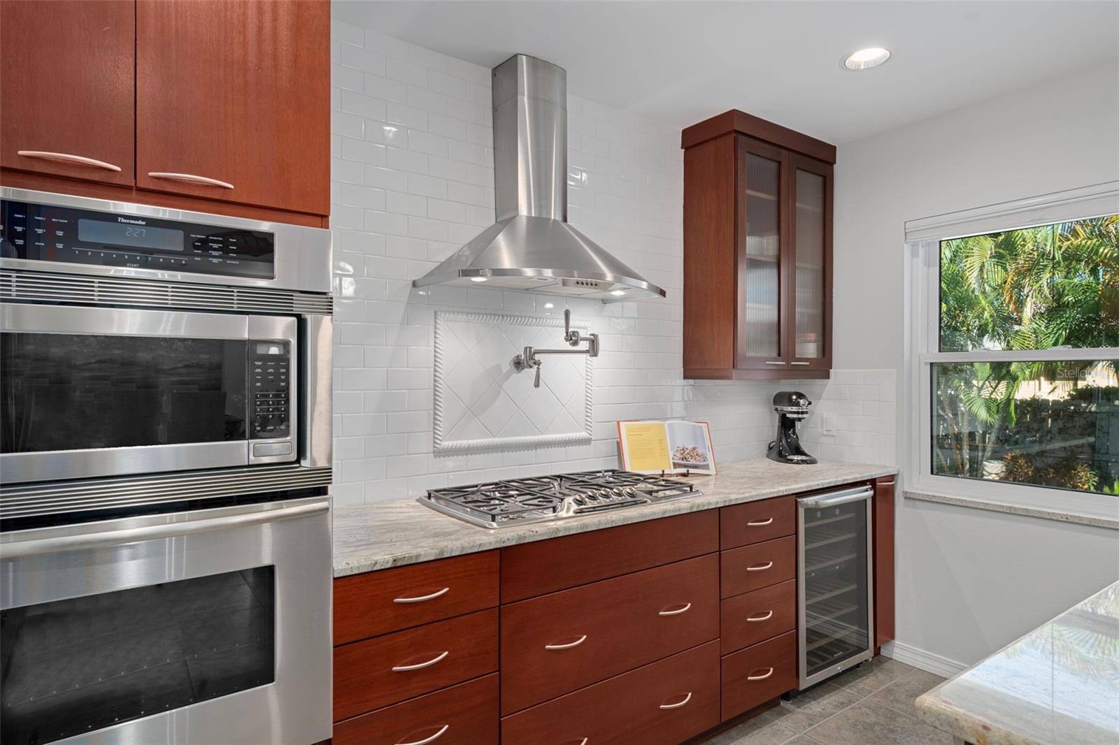 The kitchen features Thermador appliances, a five-burner gas cooktop, pot-filler, and wine refrigerator.