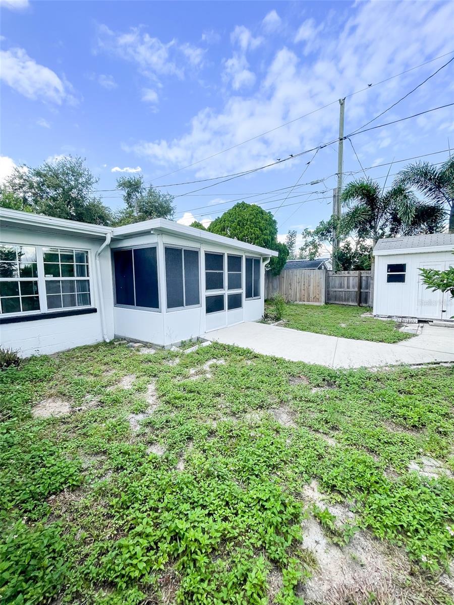 Rear of house, the screened patio has doors that open on each side of the yard.