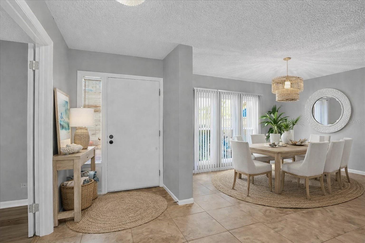 Digitally staged foyer and dining area