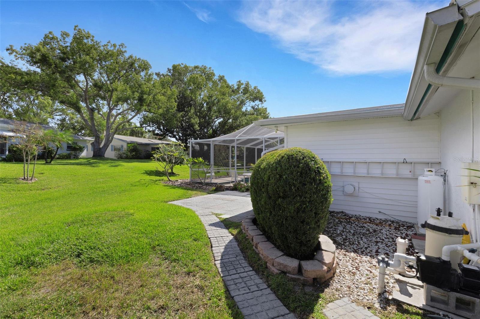 Pool pump and gas tanks for fireplace hidden behind shrubs