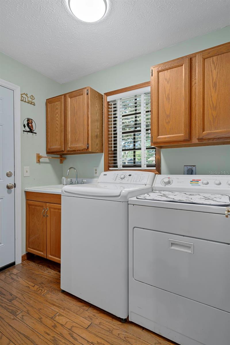Laundry Room with Cabinet Sink and Hardwood Floors
