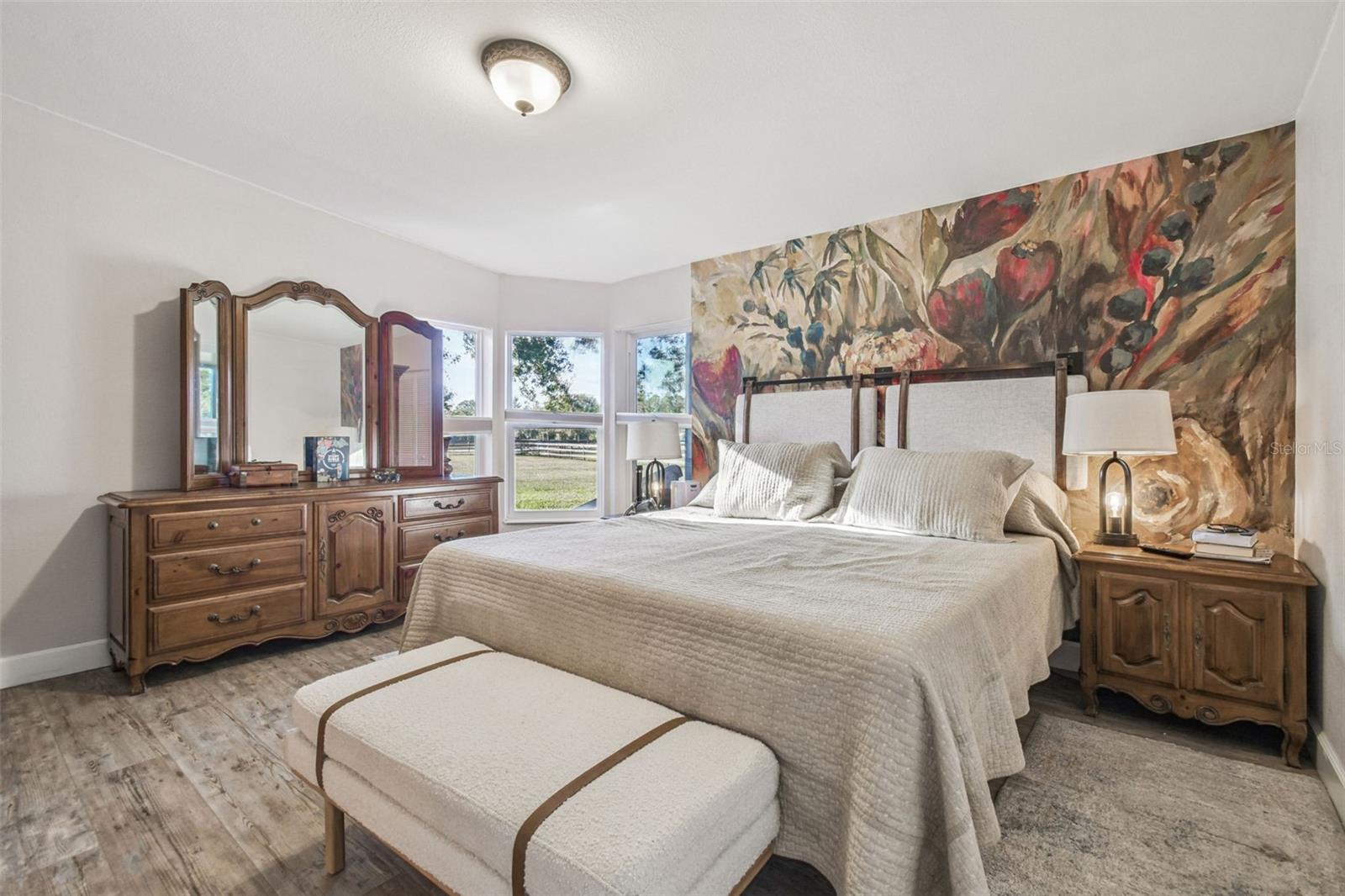 Primary bedroom with bay window has views of front pasture and arena