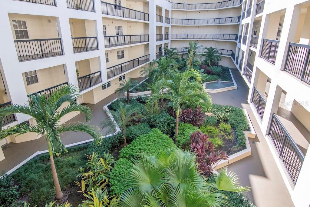 The building features a beautiful open courtyard with lush landscaping and tranquil fountains.