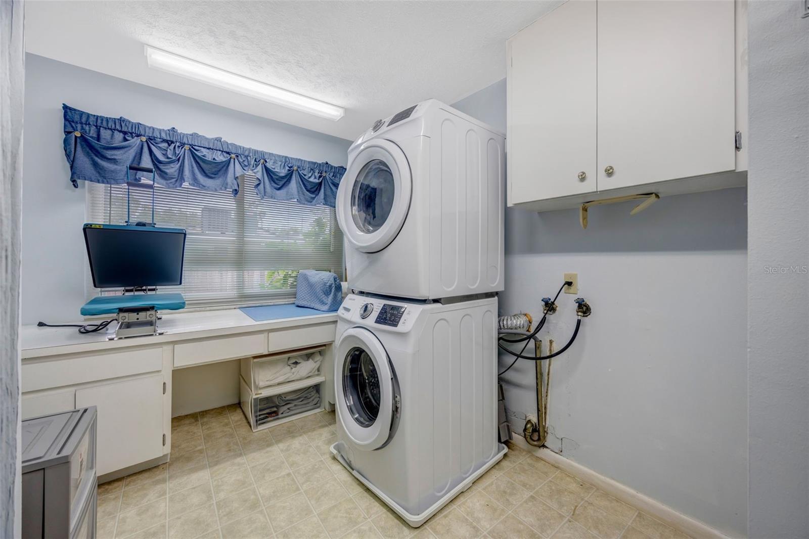 Large laundry space with workbench and closet space