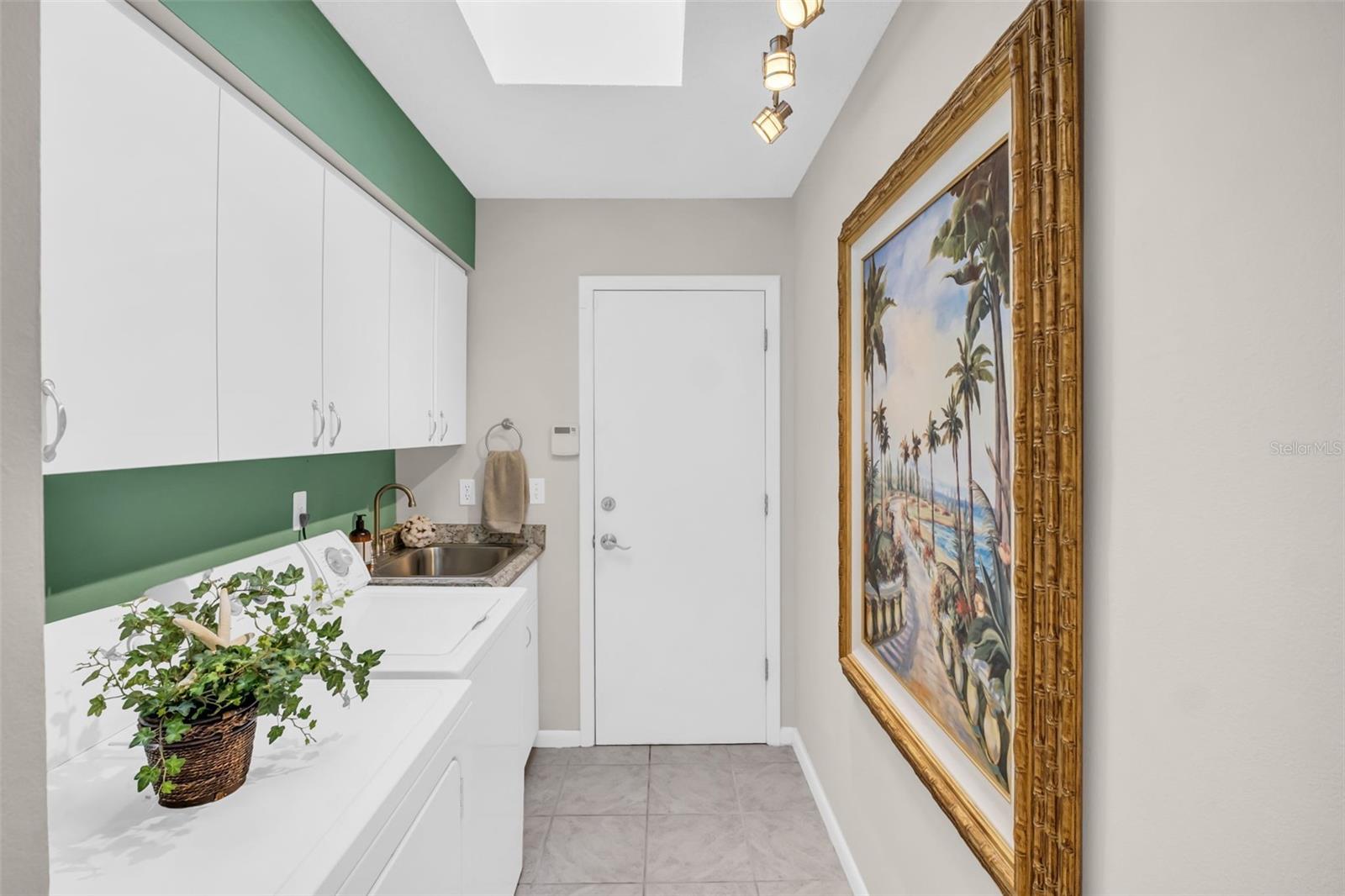 Large laundry room with additional cabinet storage, separate storage closet and convenient garage access~