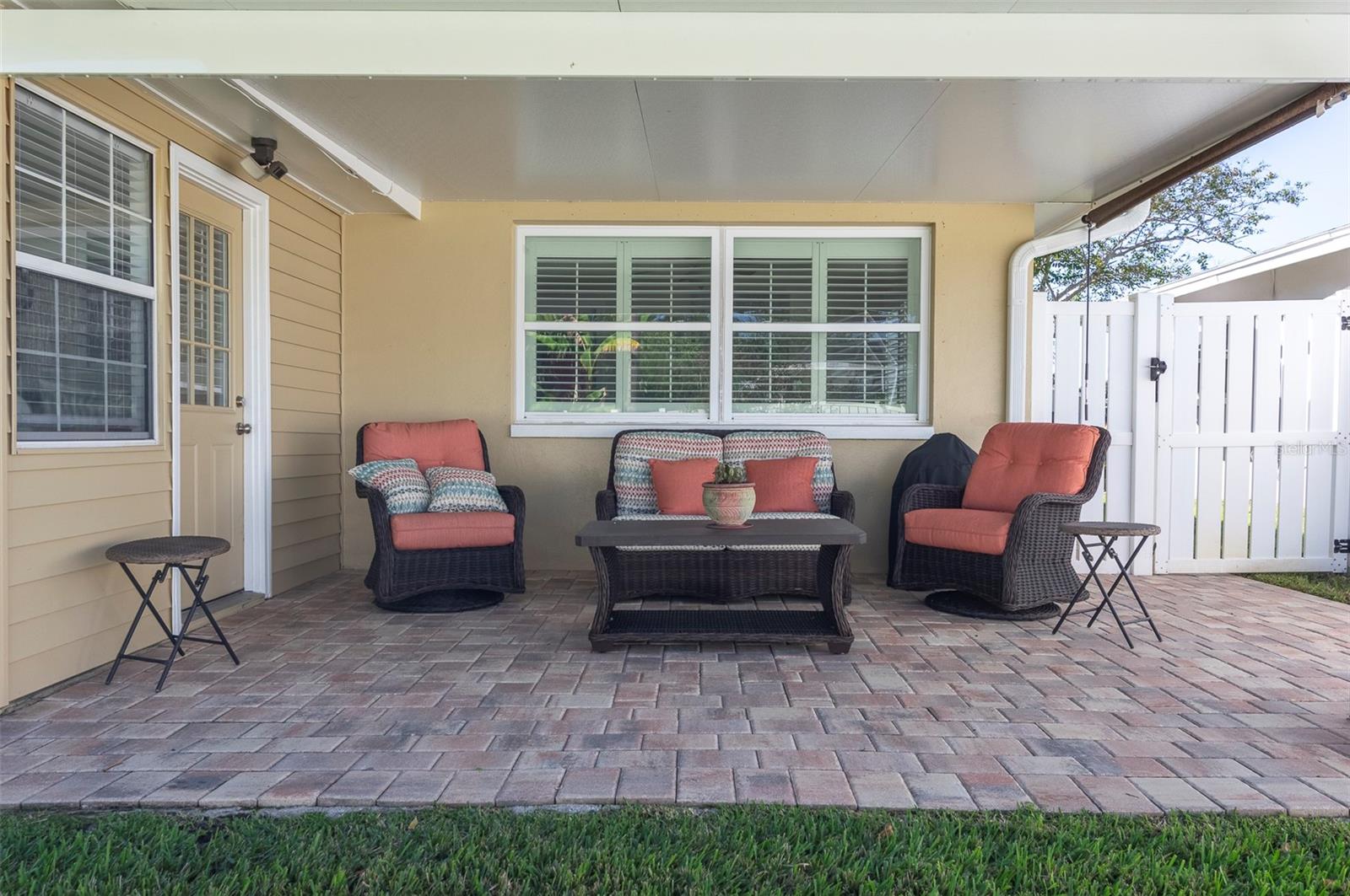 The back patio that you access from the Florida Room offers a wonderful spot to relax and read a good book or to visit with friends and neighbors. Notice on the top right that there is a pull down shade for when the late afternoon sun is shining.