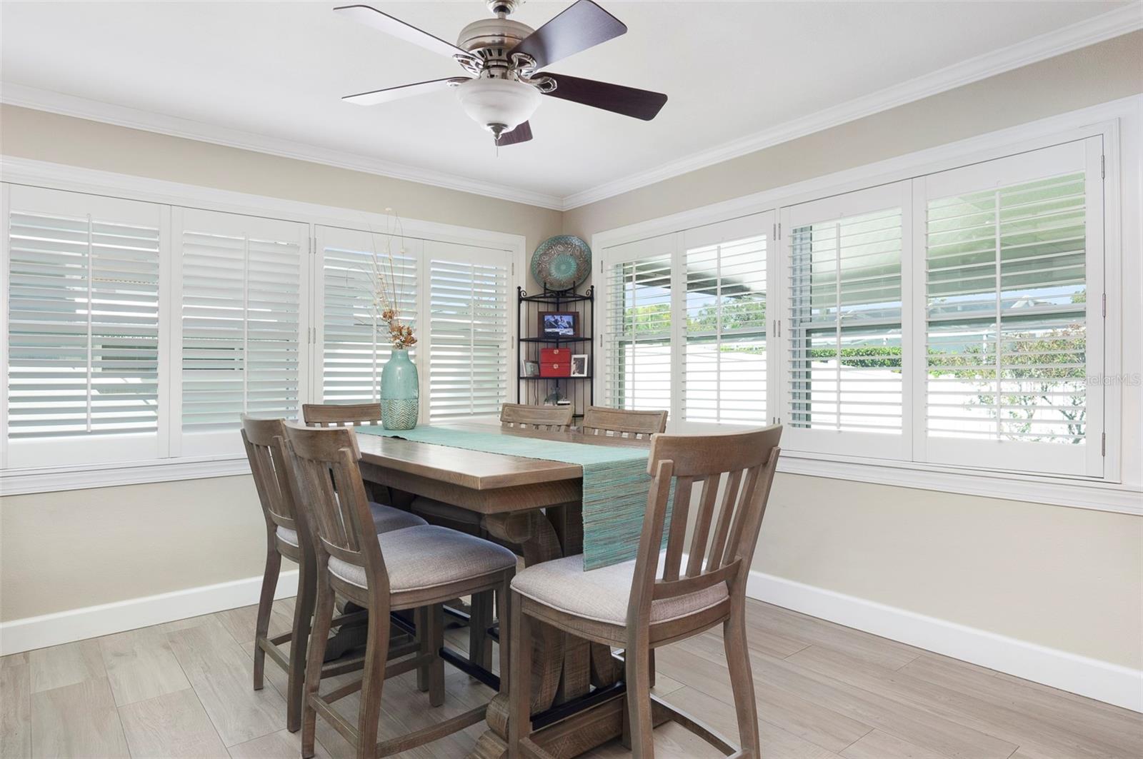 Off the kitchen is this 11X11 dining area. This room is just off the garage giving easy access to the kitchen. Note more crown molding, the same tile floors, plantation shutters, and the framed in windows!!